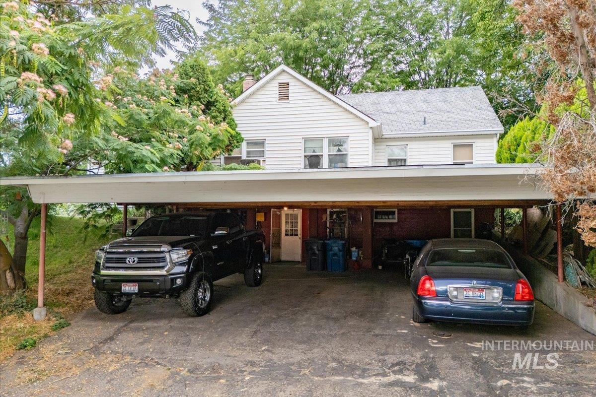 View of front of house with a chimney and view of scattered trees
