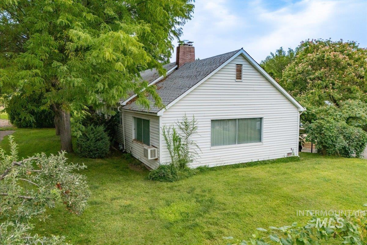 View of home's exterior featuring a lawn and a chimney