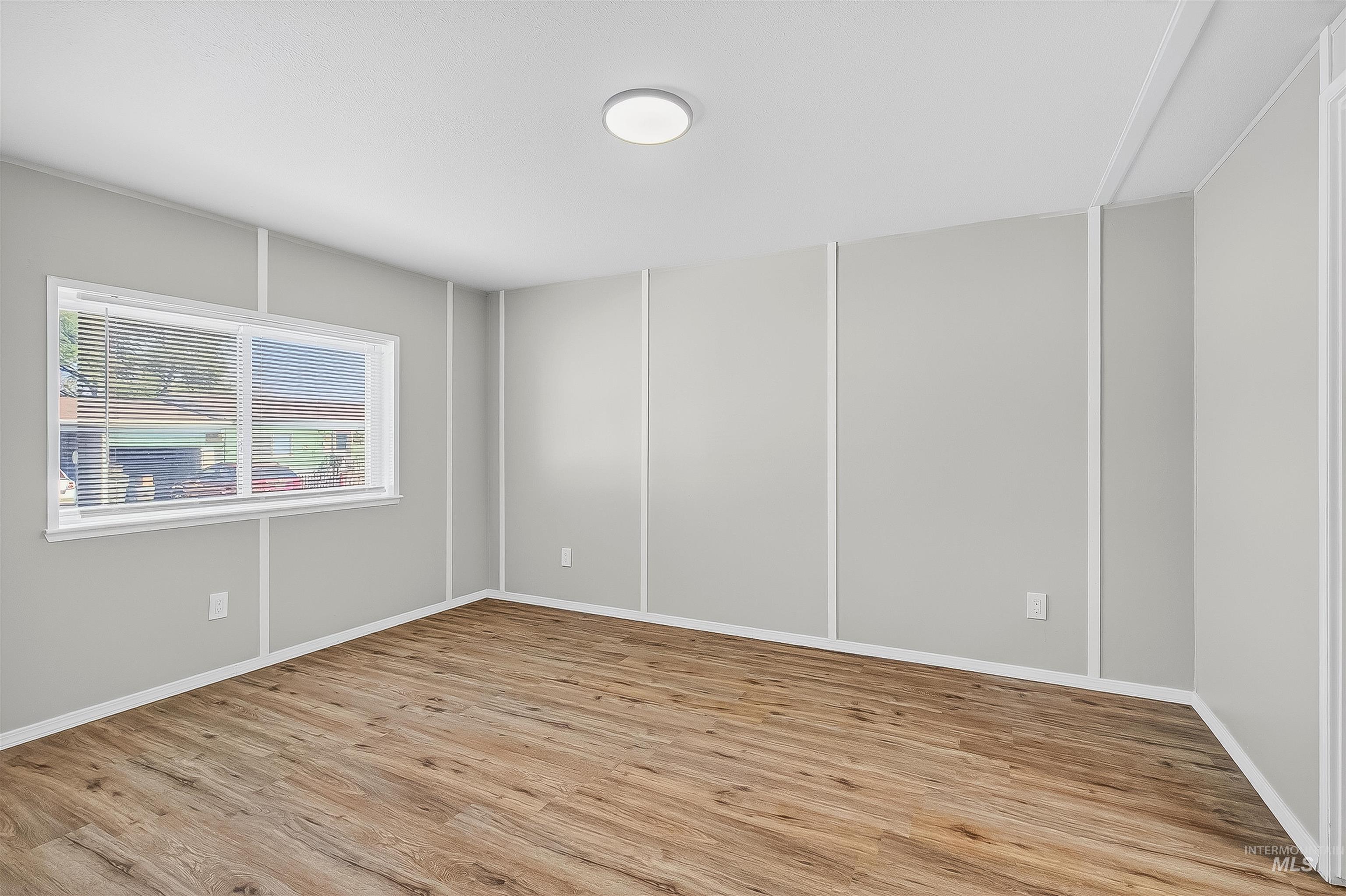 Empty room with light wood-style flooring and baseboards