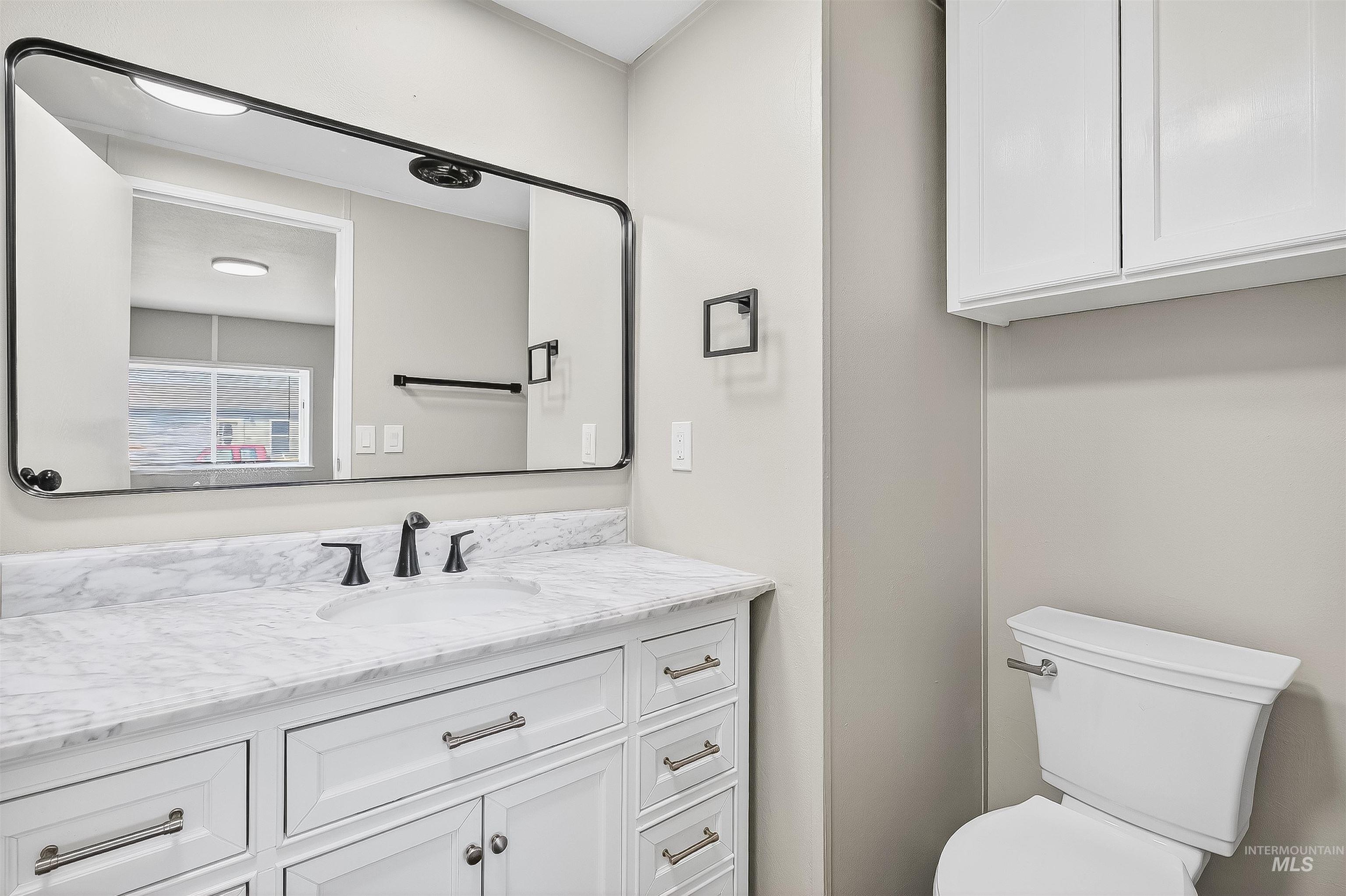 Half bathroom featuring vanity and toilet