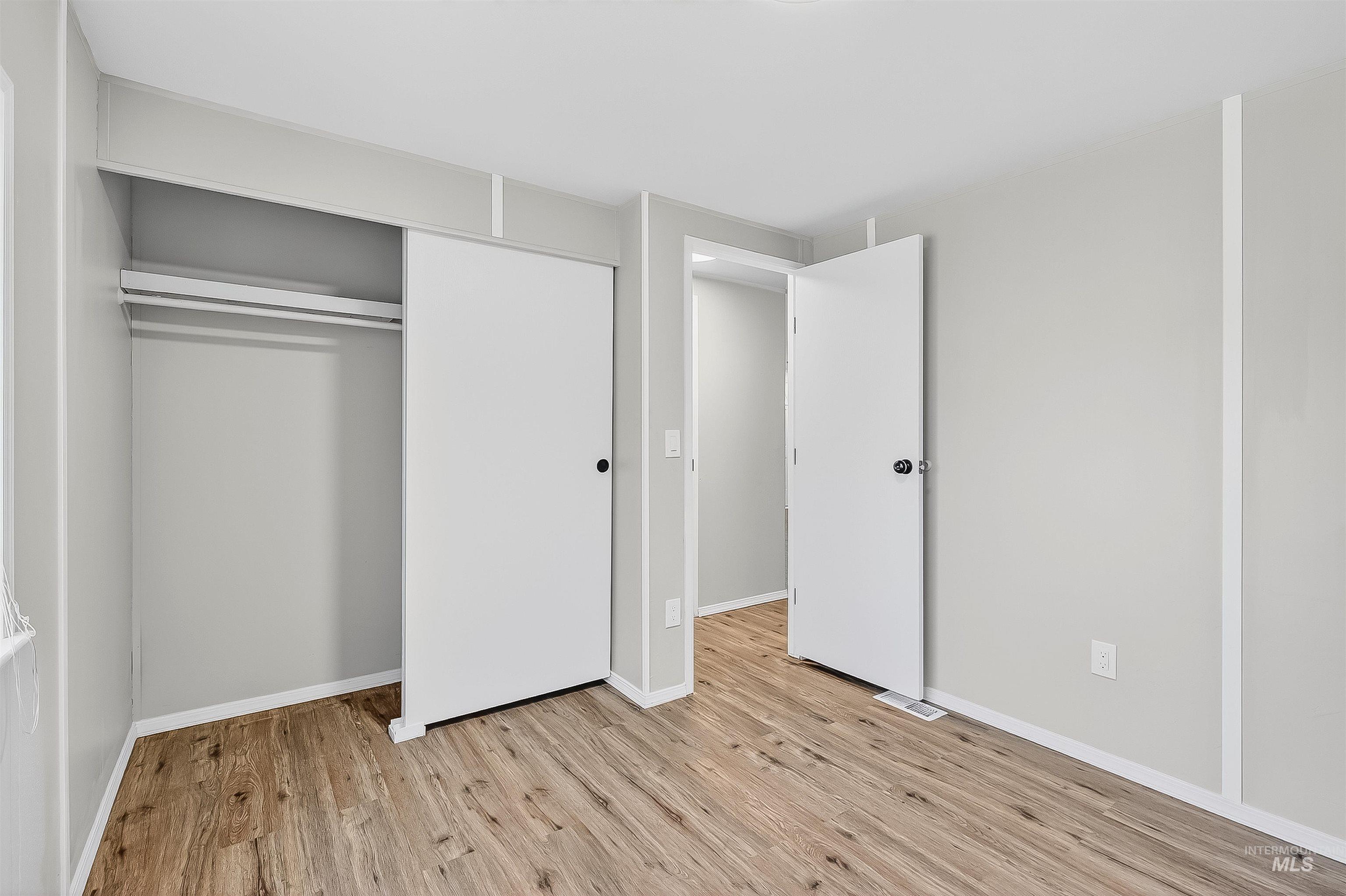 Unfurnished bedroom with light wood-style floors and a closet