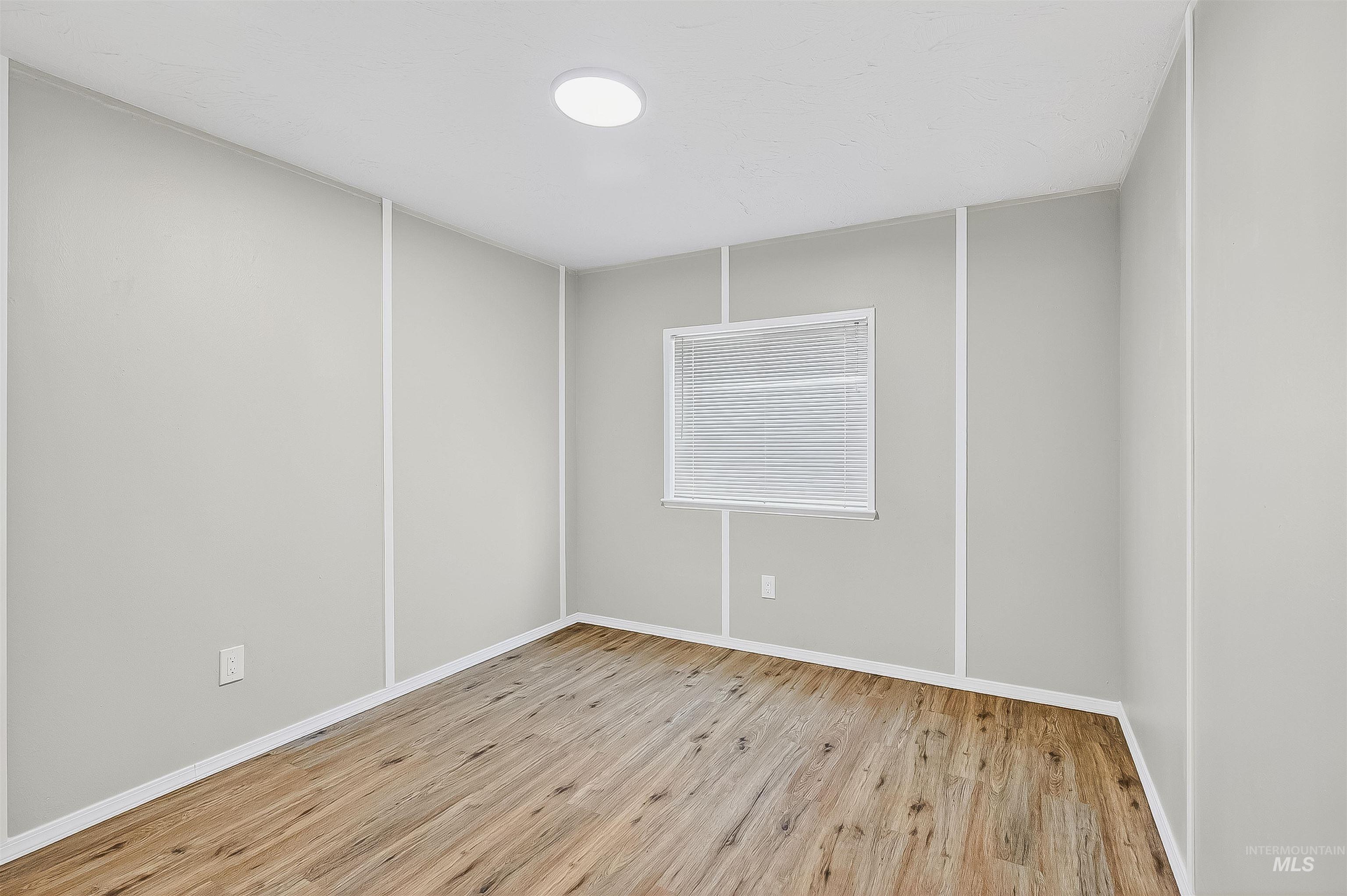 Empty room with light wood-style flooring and baseboards