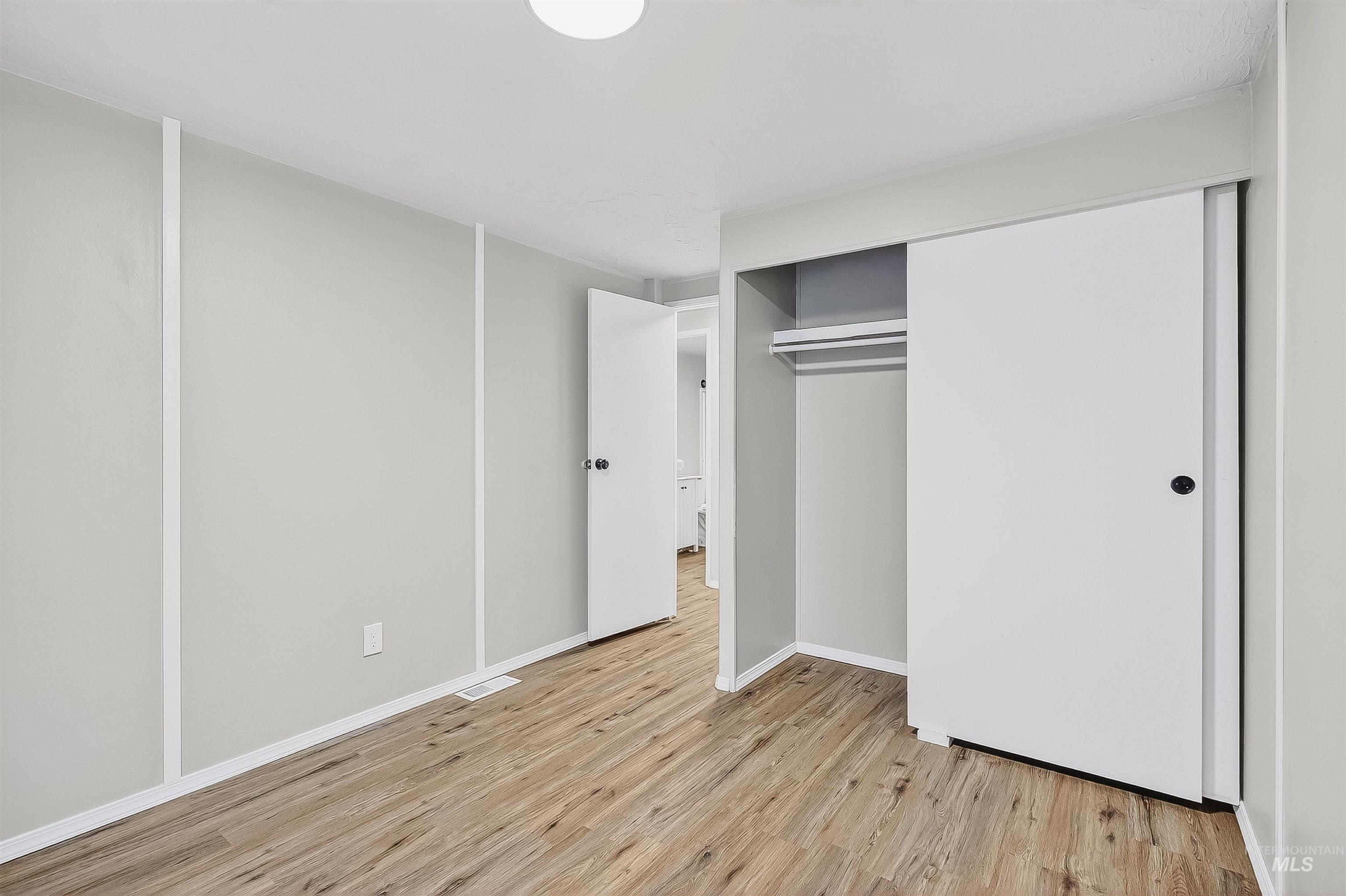 Unfurnished bedroom featuring light wood-type flooring and a closet