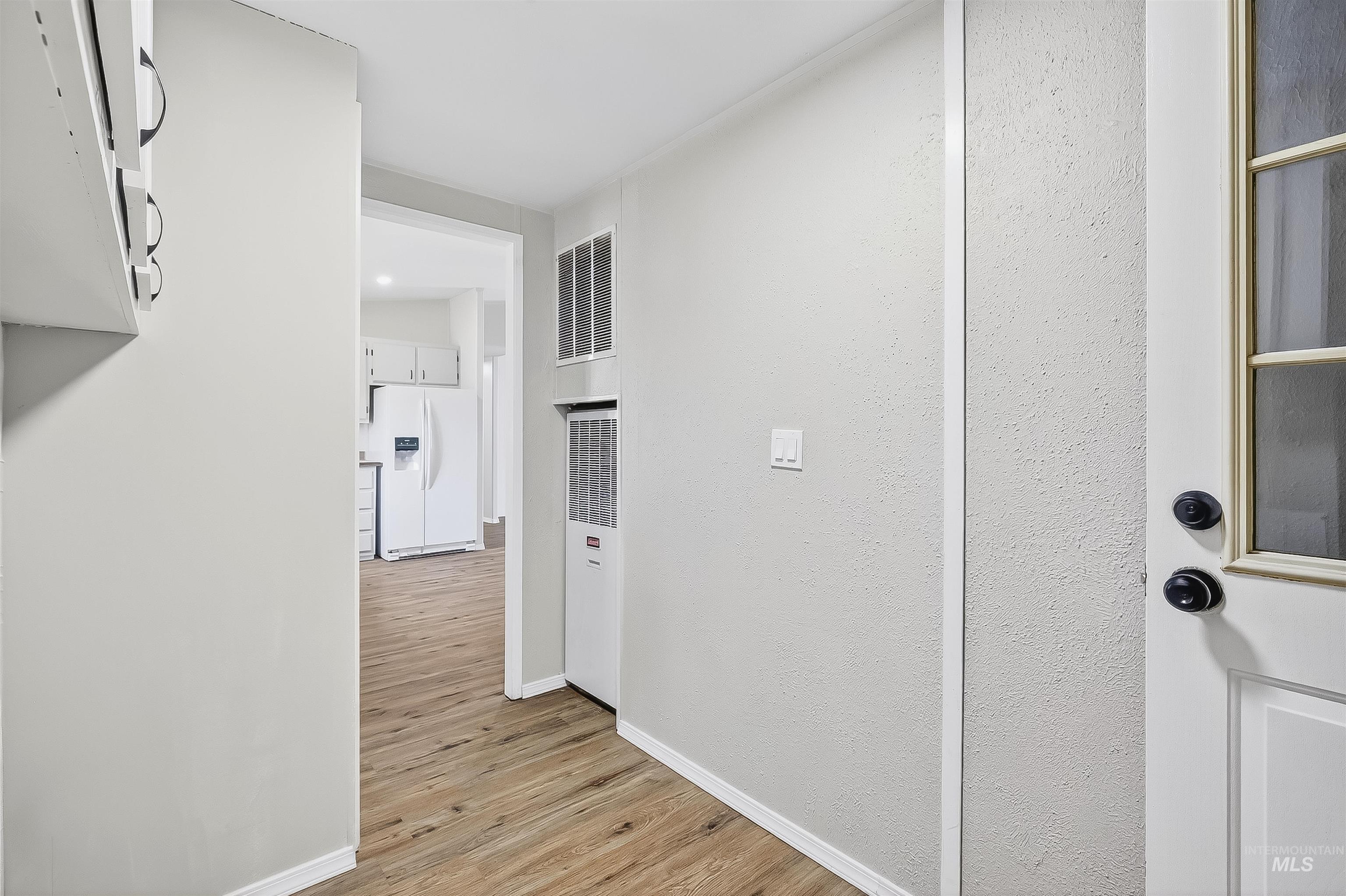 Hall featuring light wood finished floors and a heating unit