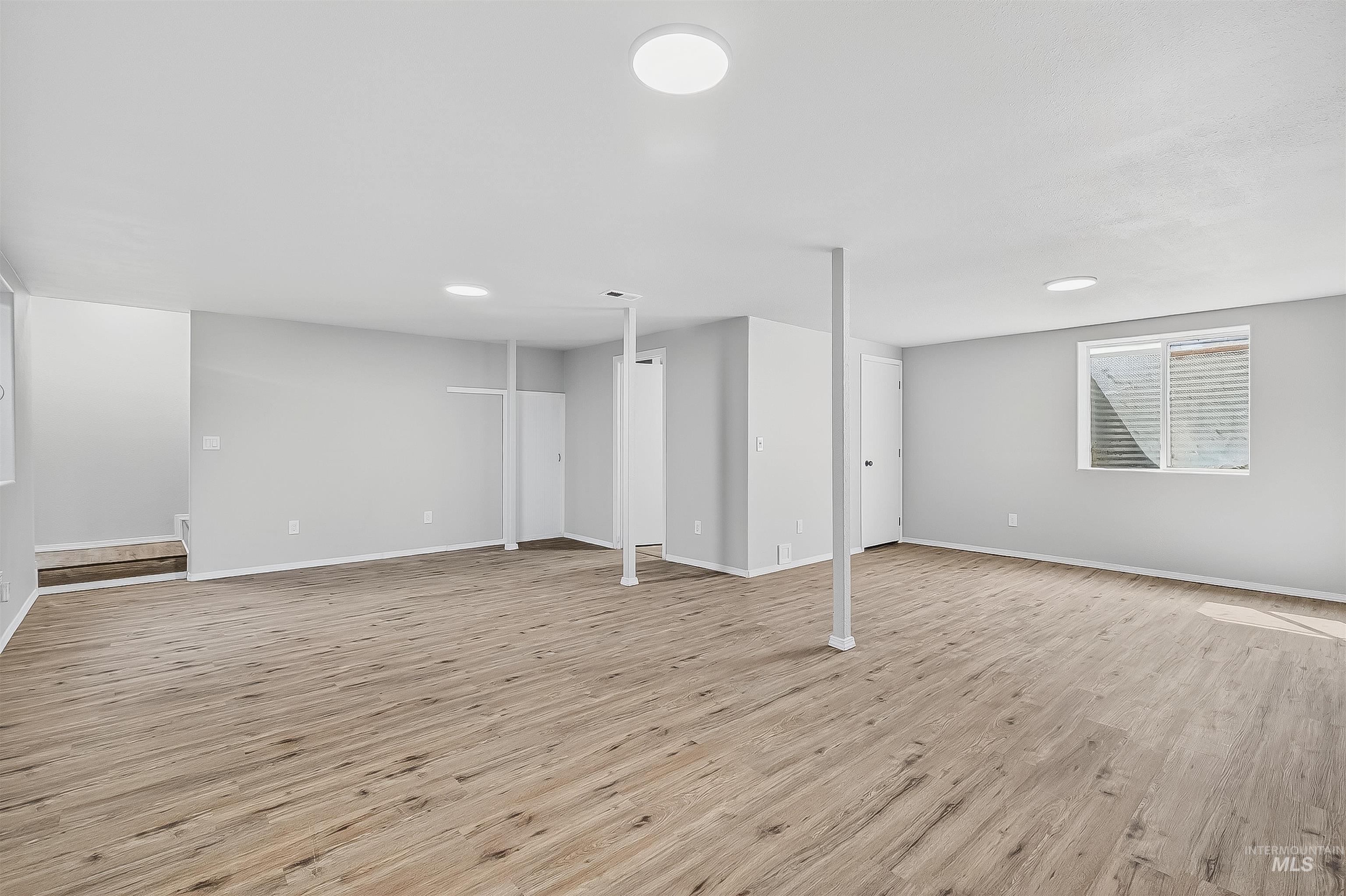 Basement with light wood-style flooring