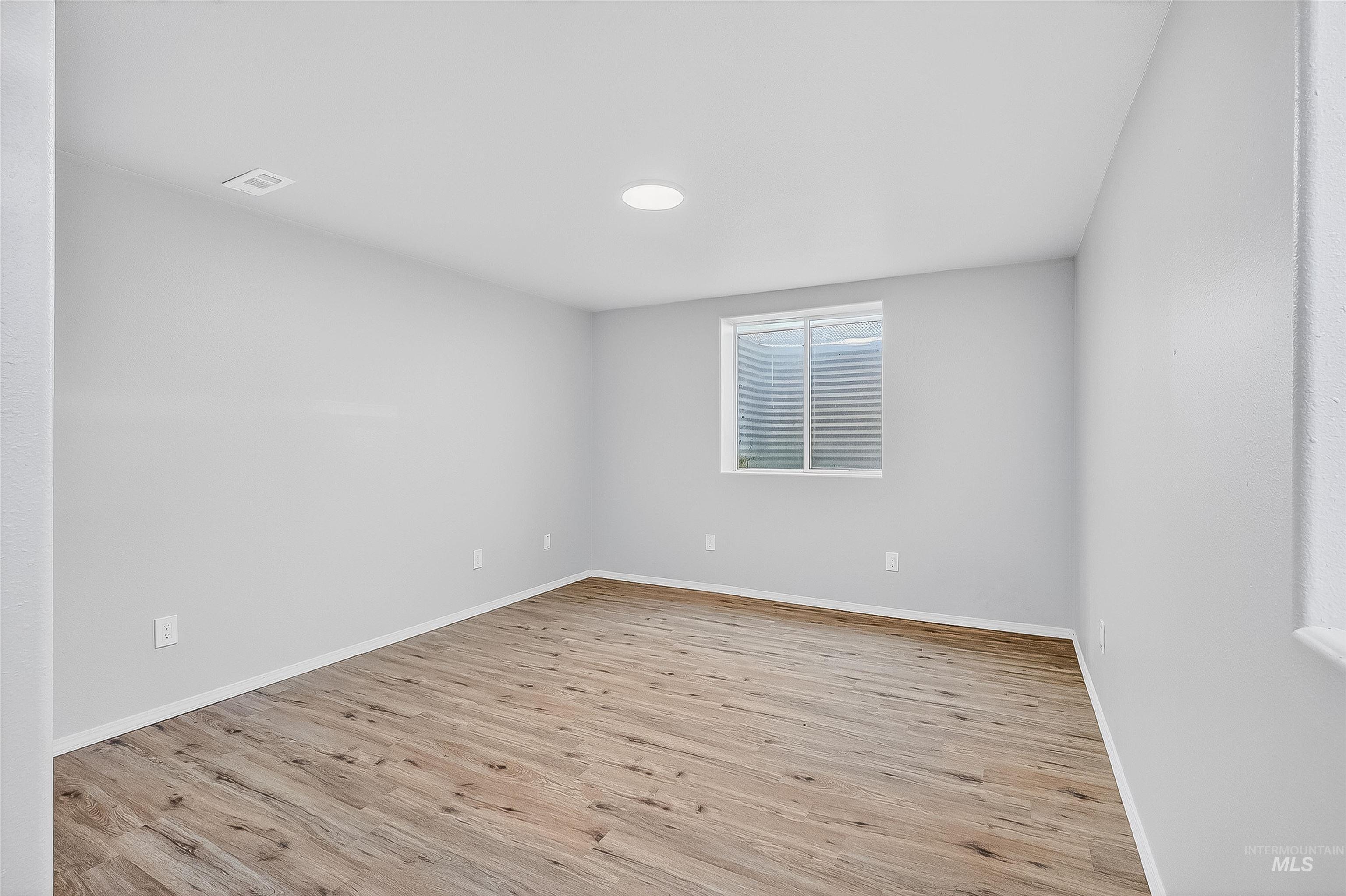Empty room featuring light wood-type flooring and baseboards