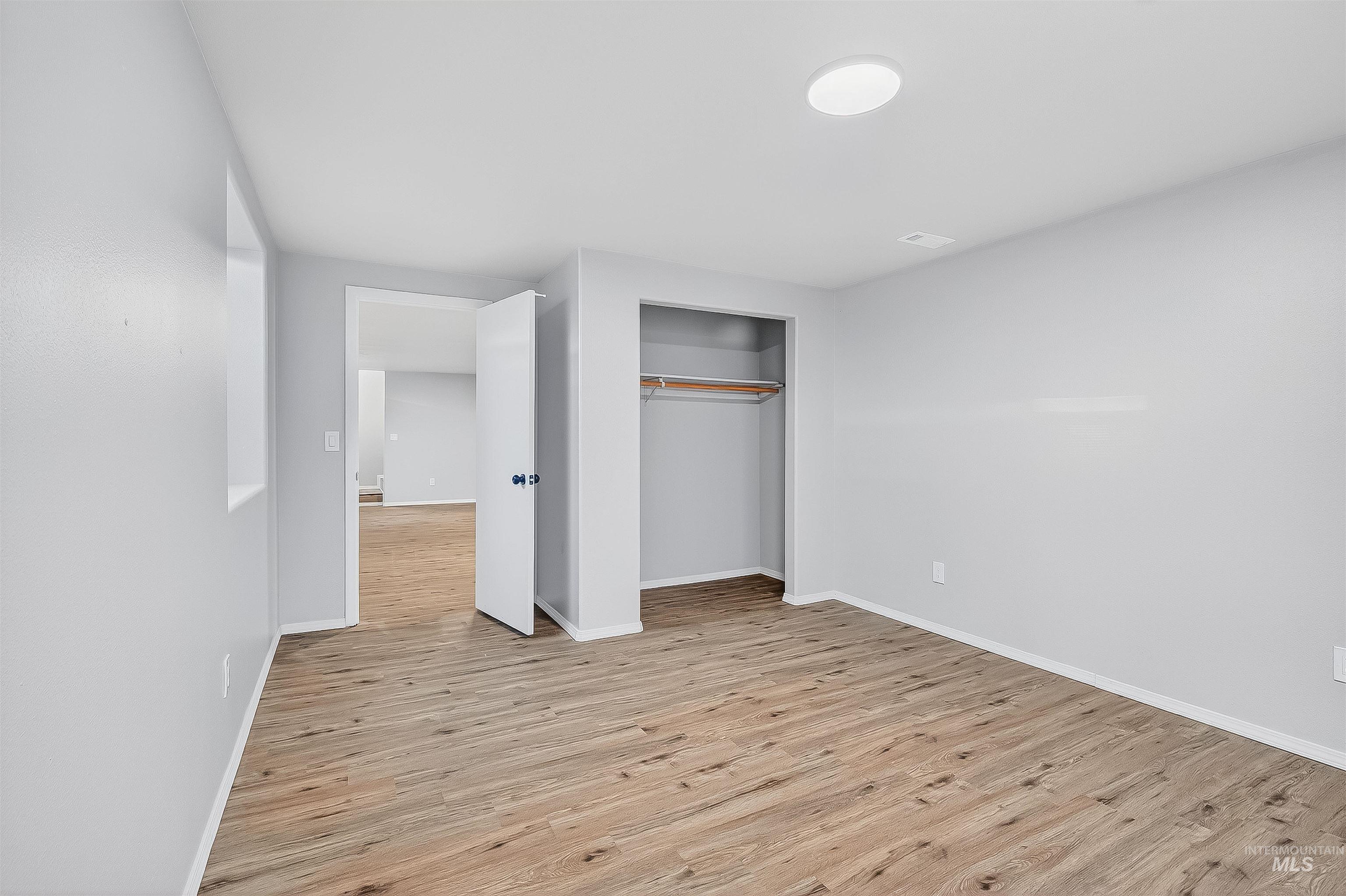 Unfurnished bedroom with light wood-style flooring and a closet