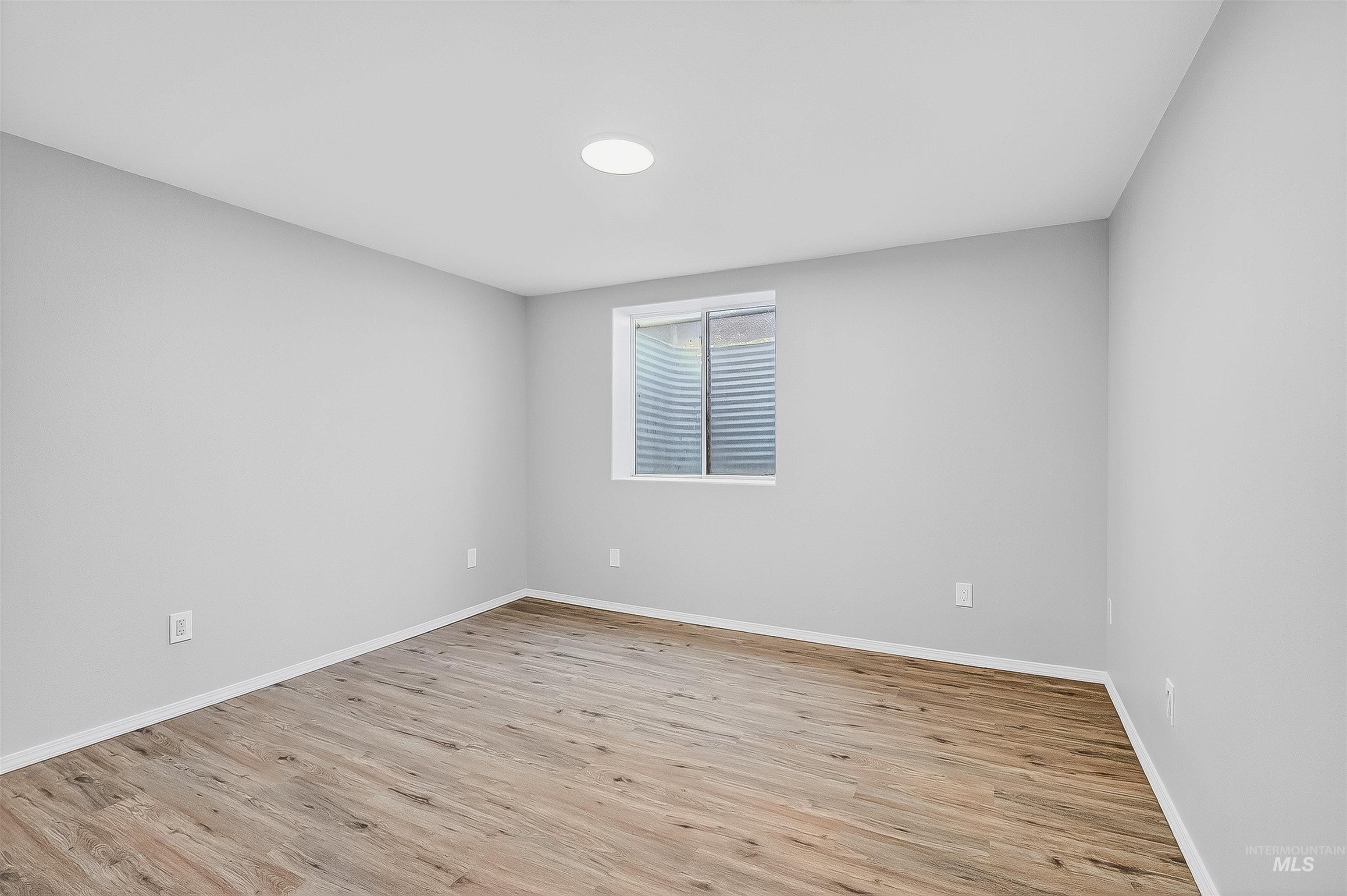 Empty room with light wood finished floors and baseboards