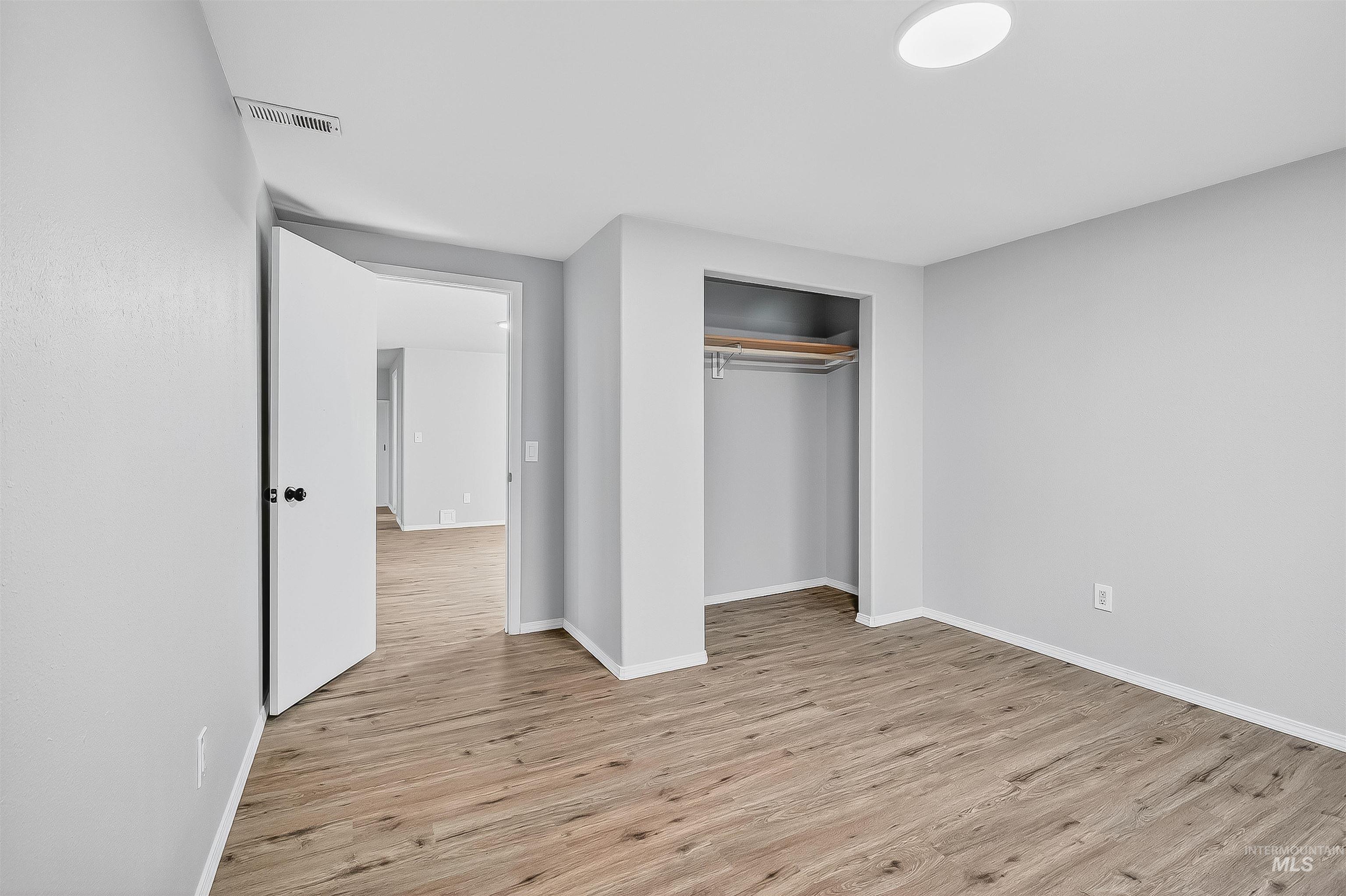 Unfurnished bedroom with light wood-style flooring and a closet