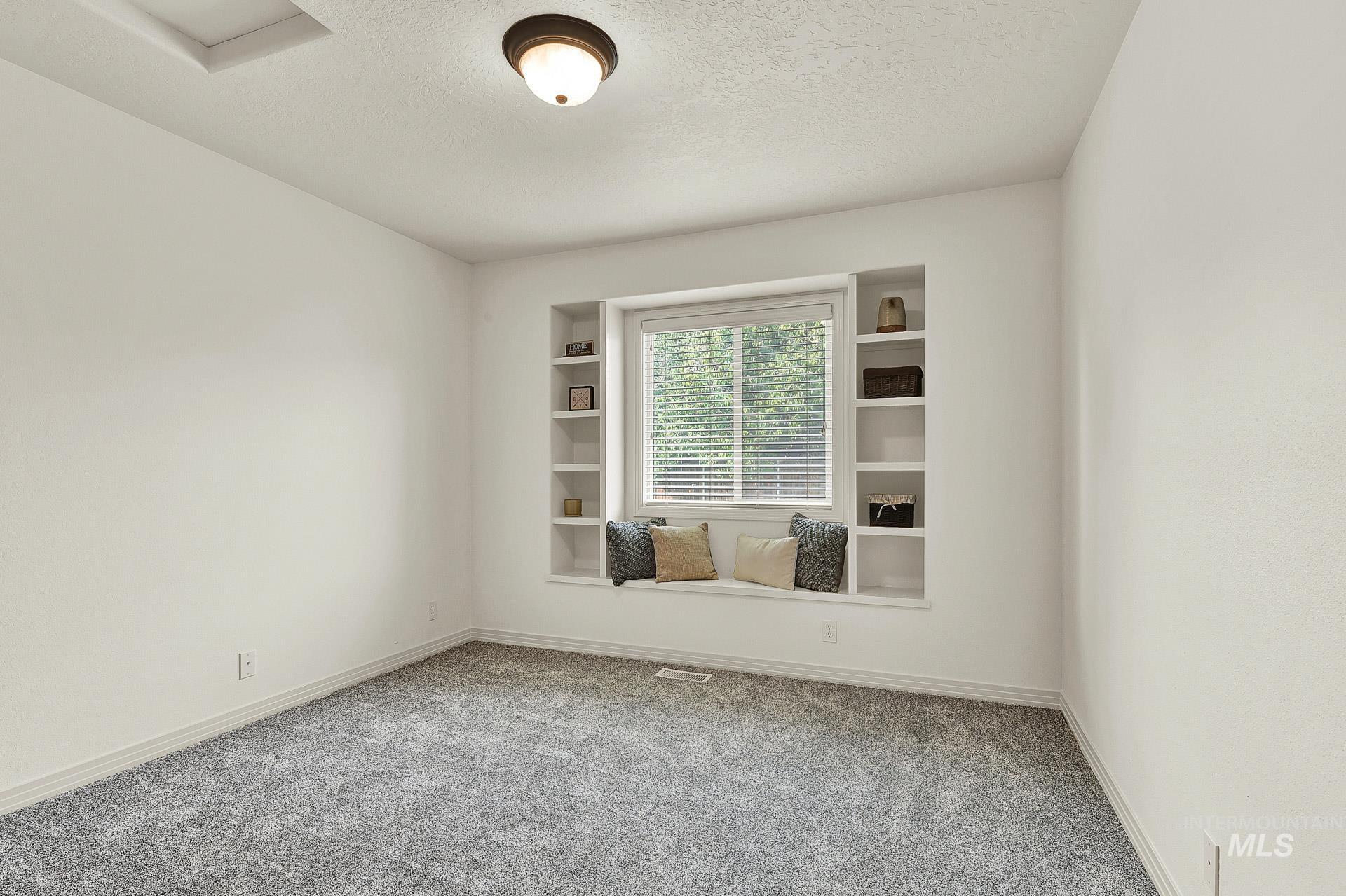 Bedroom #2 Good size bedroom featuring built in display shelves and a window seat.  Newly installed carpeting, and the closet has custom shelving and a generous amount of room.