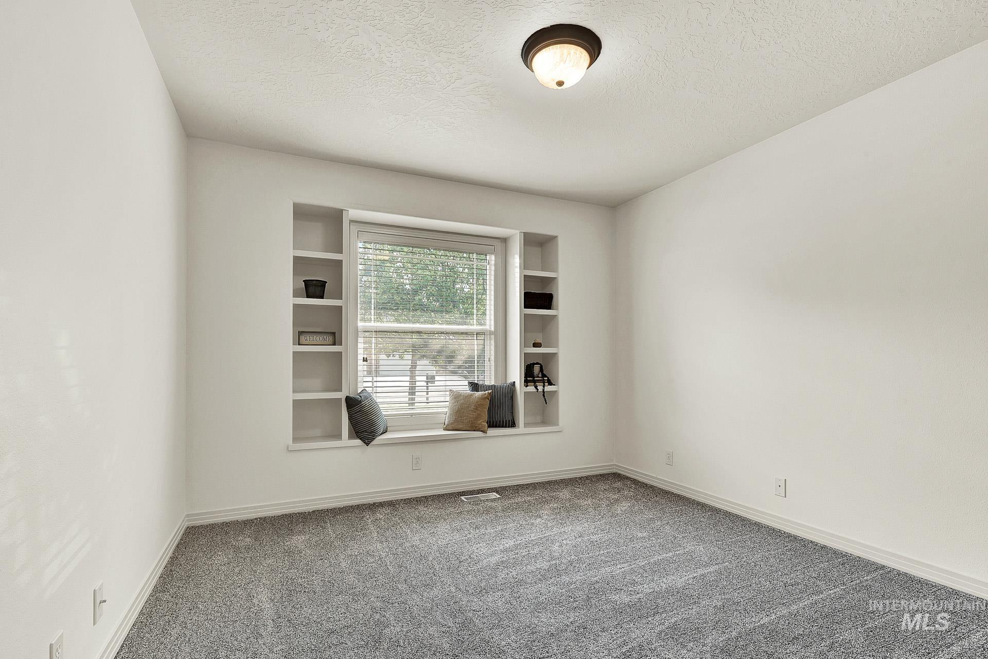 Bedroom #3 Good size bedroom featuring built in display shelves and a window seat.  Newly installed carpeting, and the closet has custom shelving and a generous amount of room.