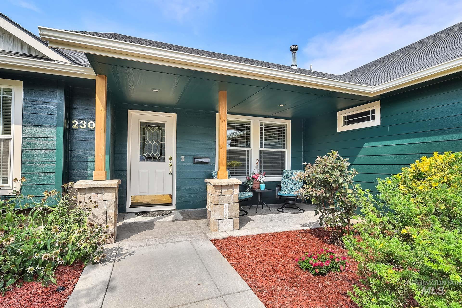 Ranch-style house with nice stone accents, new exterior paint and featuring a front yard with established trees, a porch, concrete driveway, and an attached oversized 3 car garage.