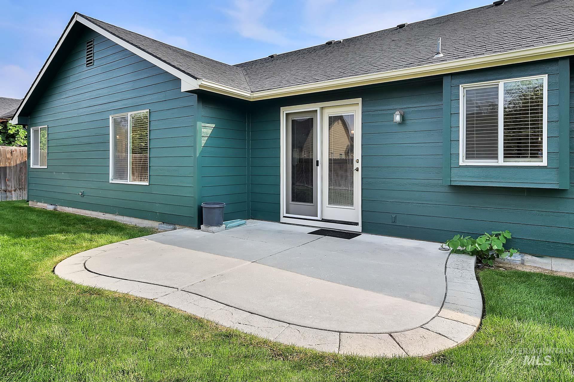 Back of property featuring a patio area, room to set up a BBQ and enjoy this lush green backyard