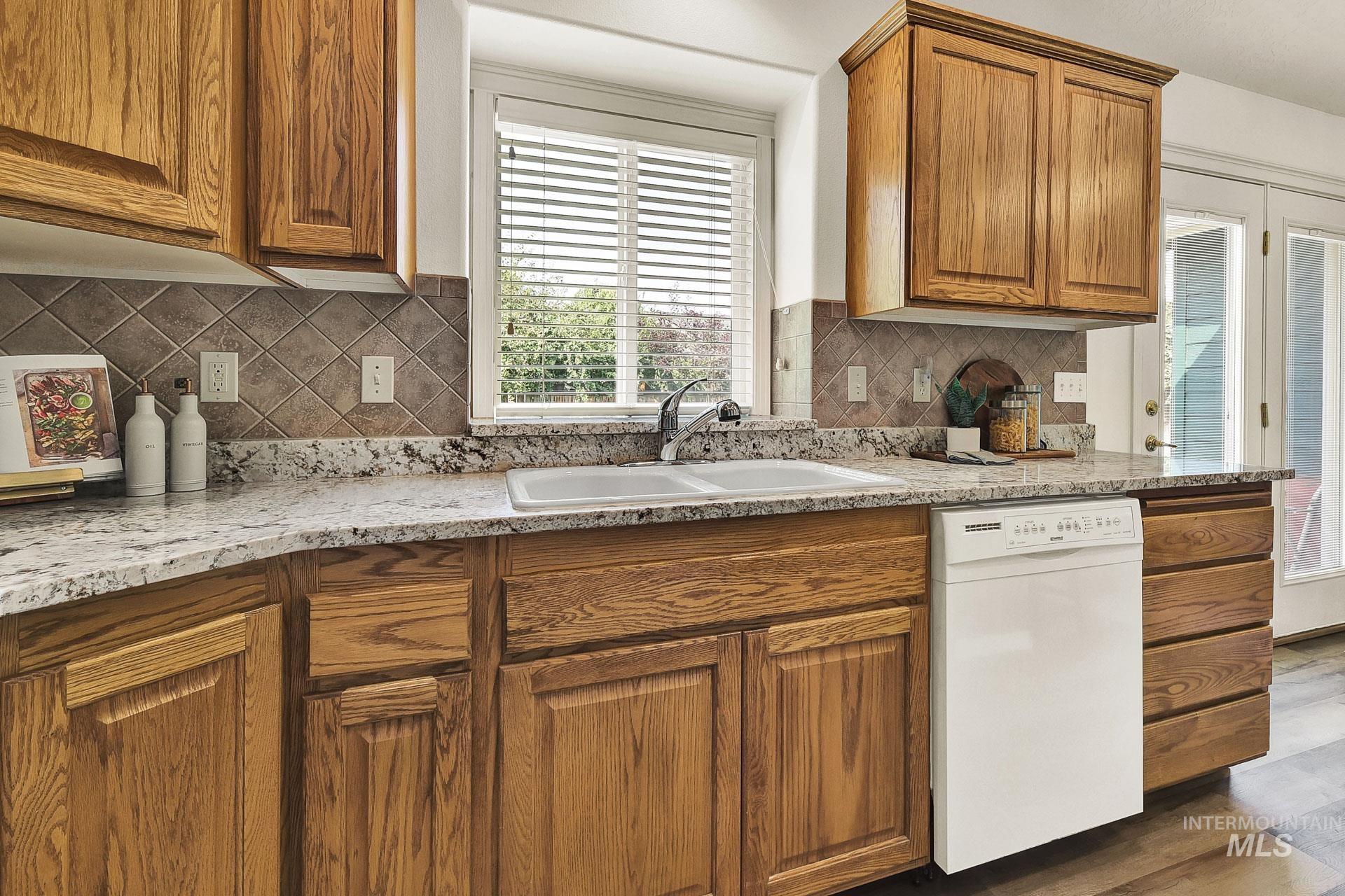 Kitchen with solid wood cabinetry, extra roomy pantry, bisque appliances, newly installed beautiful granite counters and window sill, plenty of countertop area, vaulted ceiling and new LVP flooring.