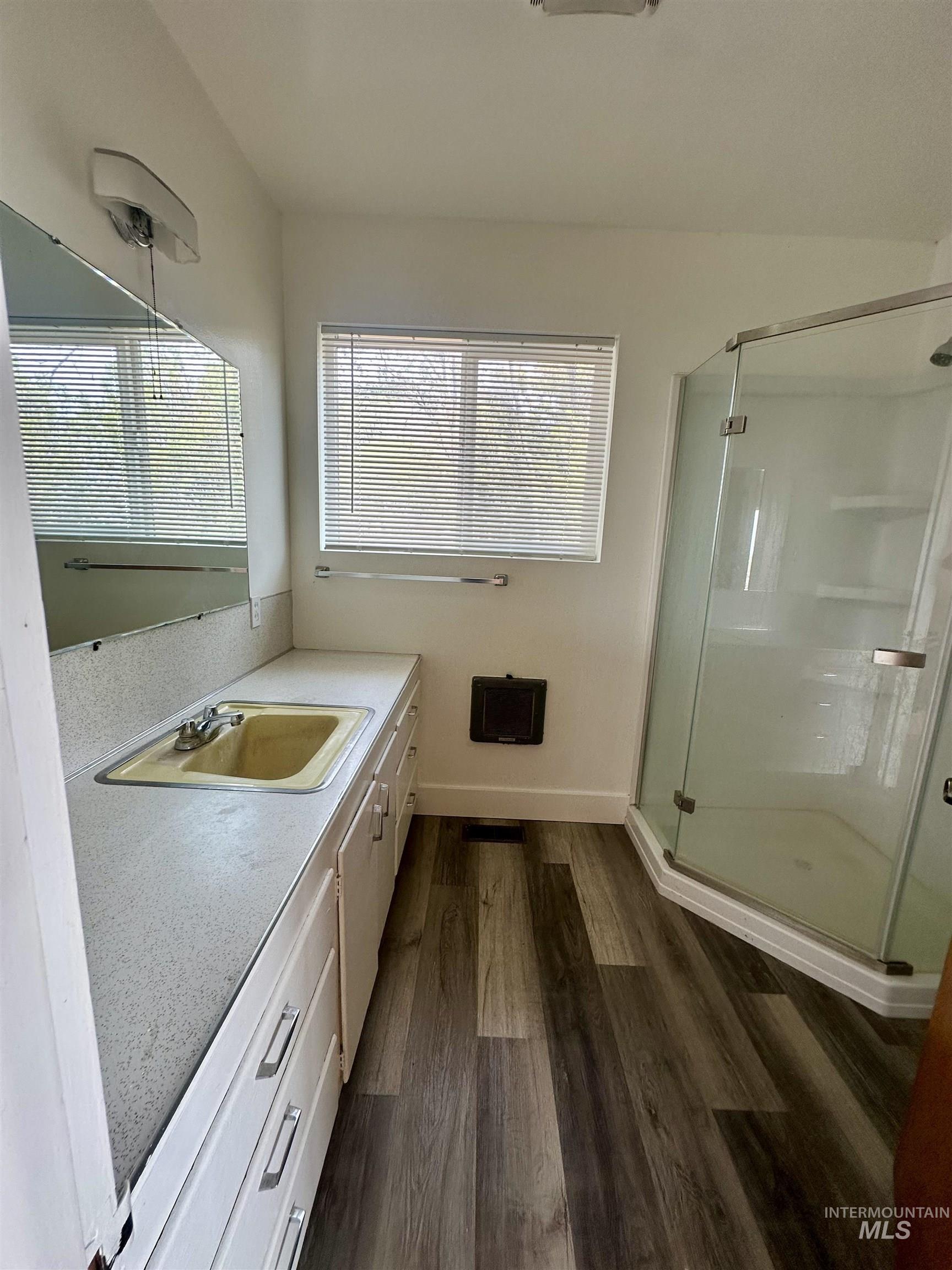 Full bathroom featuring vanity, a shower stall, and dark wood-type flooring