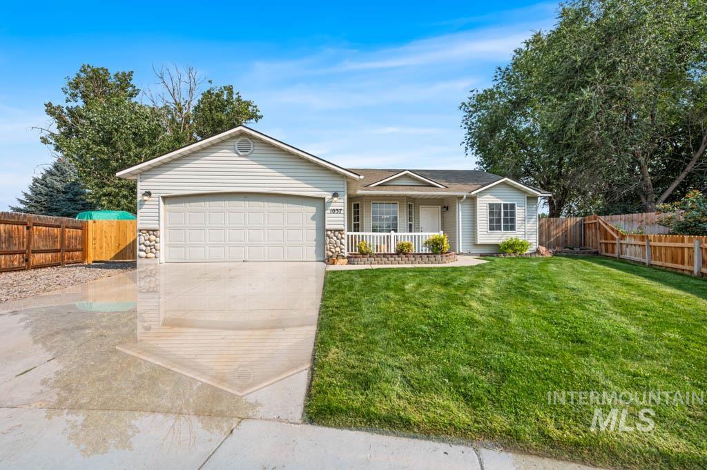 Single story home with concrete driveway, stone siding, an attached garage, and a porch