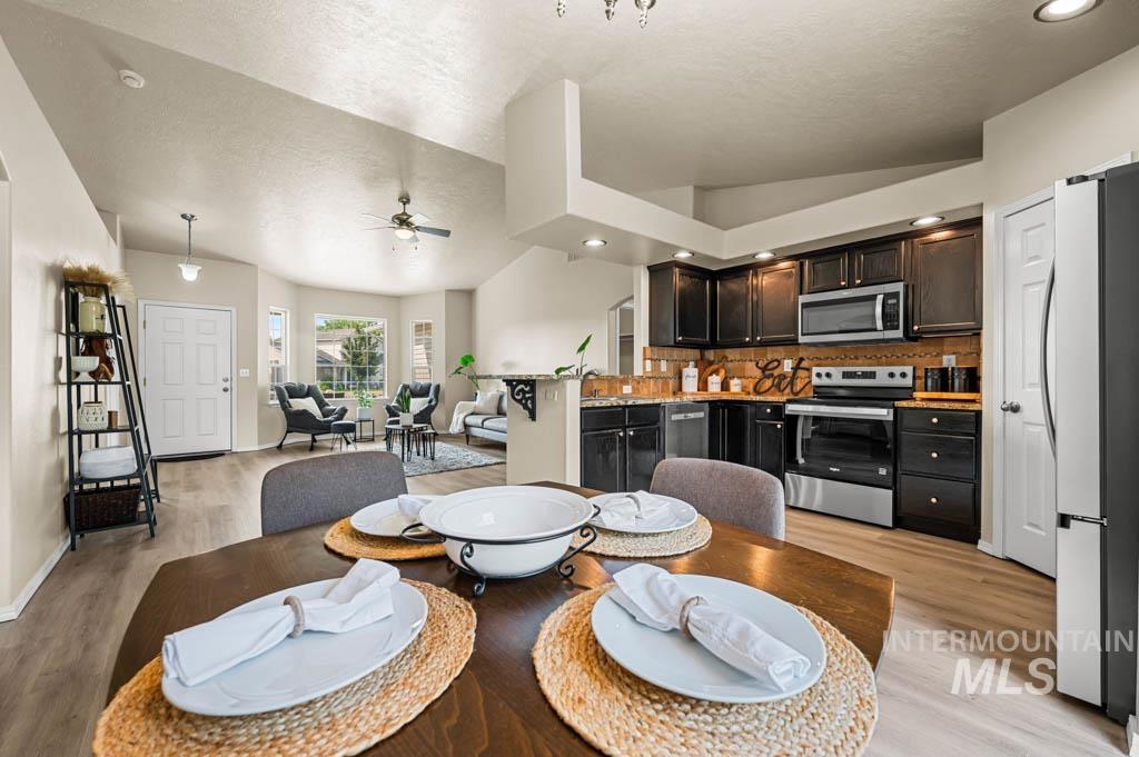 Dining area featuring lofted ceiling, light wood-type flooring, ceiling fan, a textured ceiling, and recessed lighting