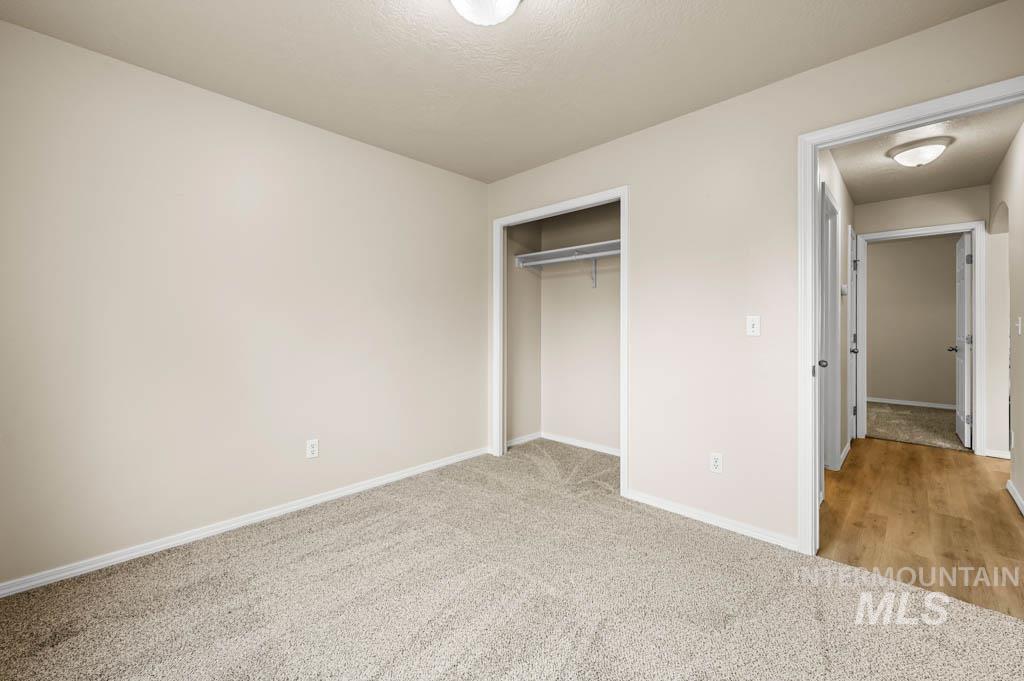 Unfurnished bedroom with light colored carpet and a closet