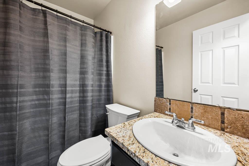 Bathroom with vanity, curtained shower, and a textured wall