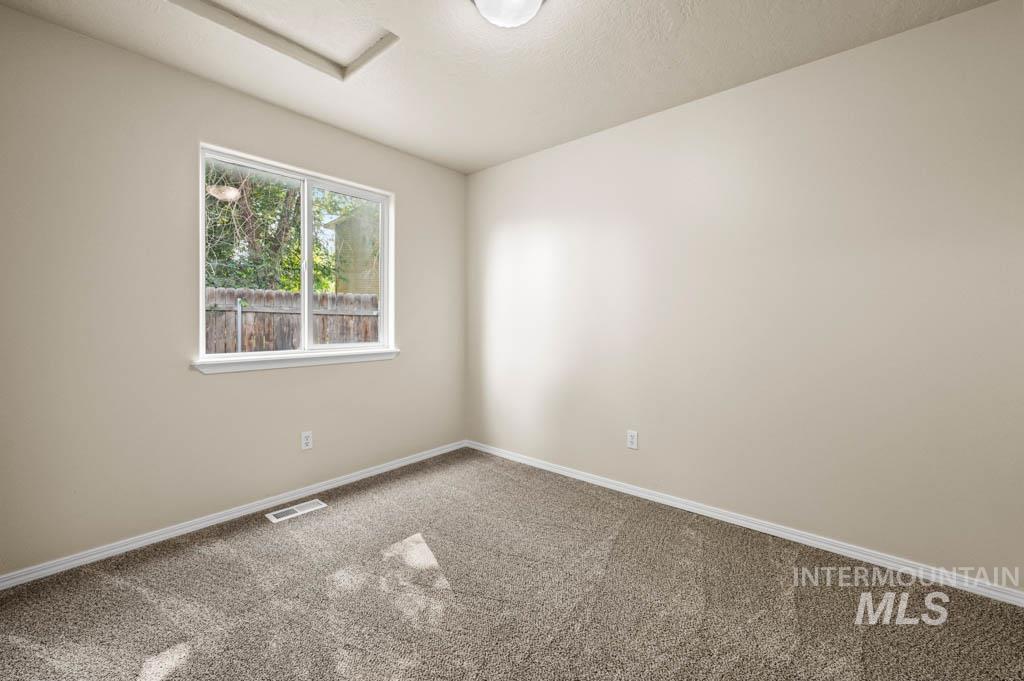 Carpeted empty room with baseboards and a textured ceiling