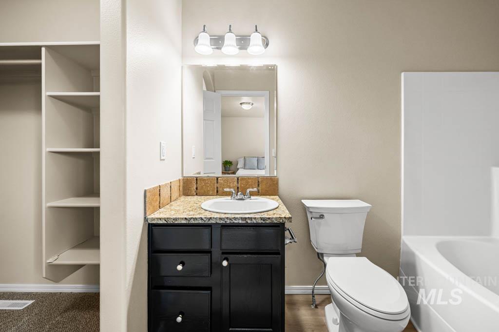 Bathroom with vanity and large / shower combination