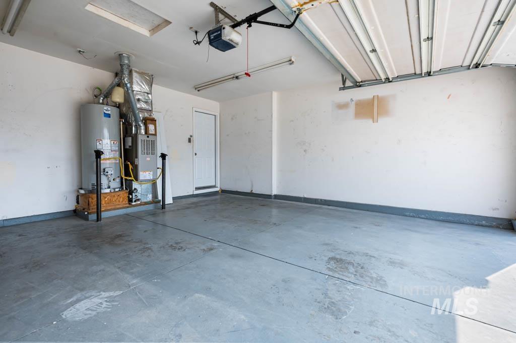 Garage featuring water heater and a garage door opener