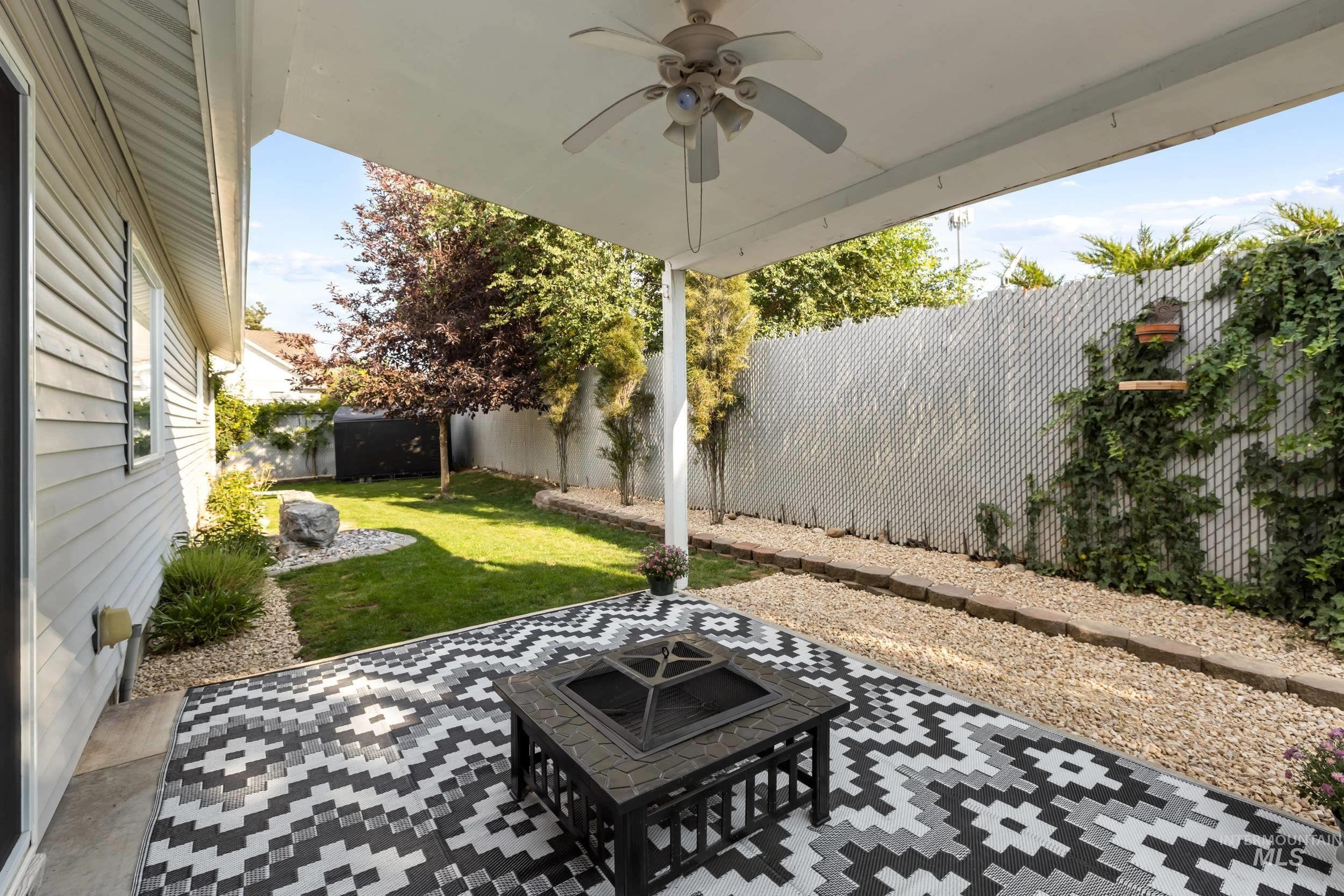 Fenced backyard featuring a patio area and ceiling fan