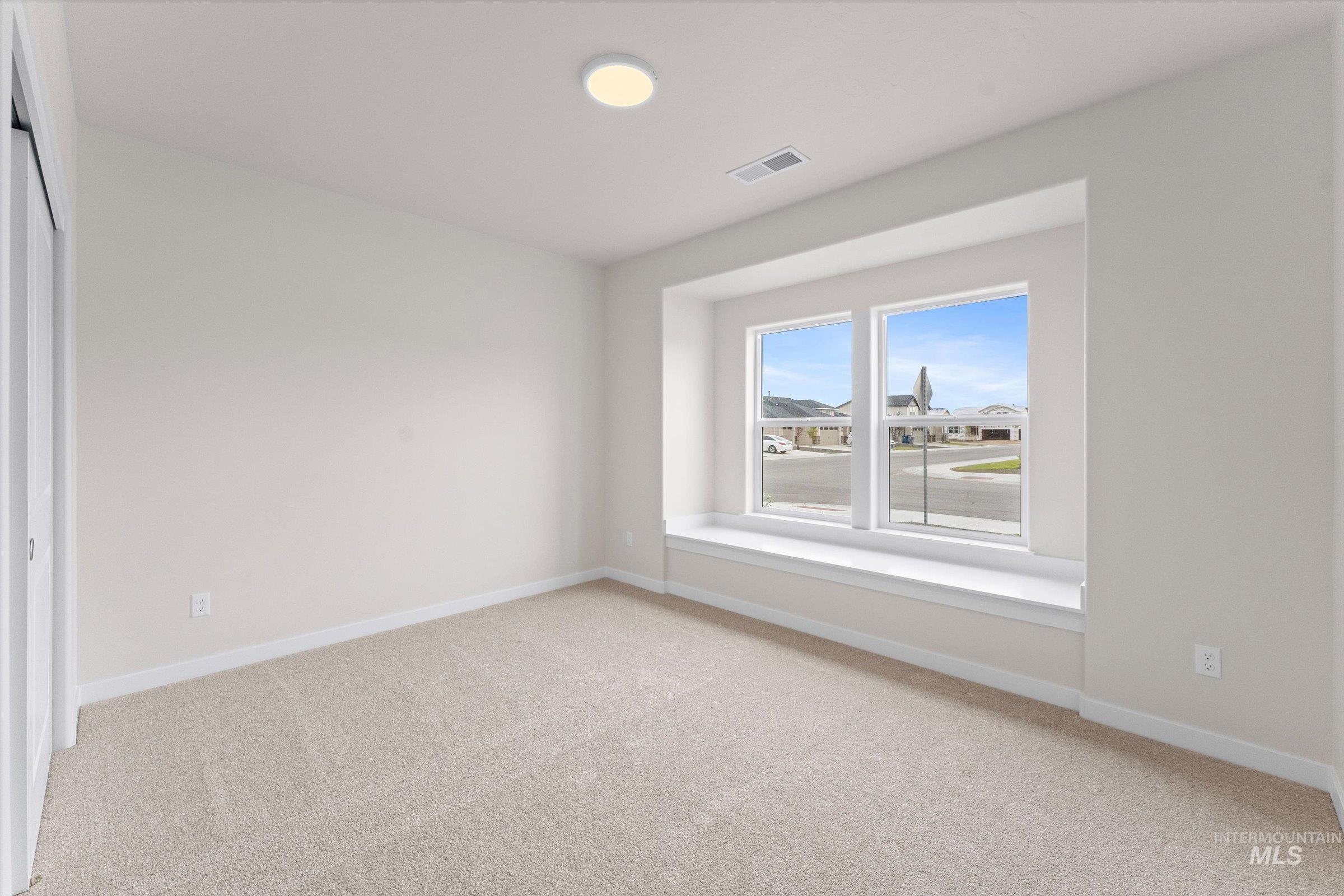 Unfurnished room with light colored carpet and baseboards