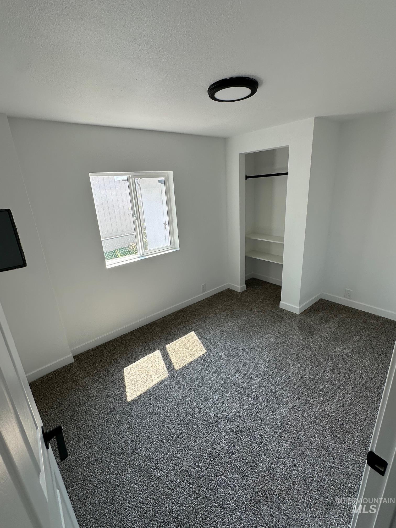 Unfurnished bedroom with carpet, a textured ceiling, and a closet