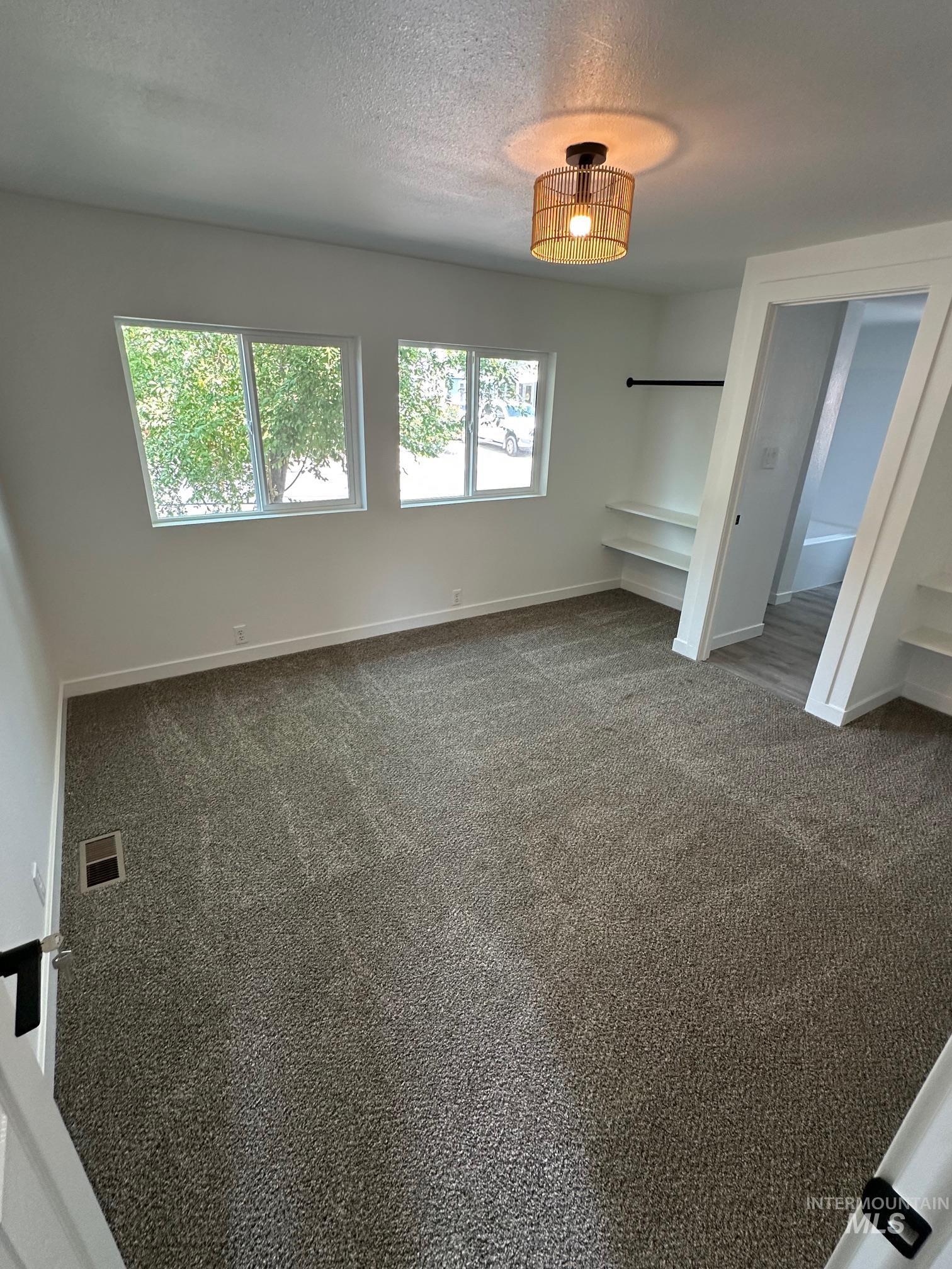 Unfurnished bedroom featuring carpet flooring and a textured ceiling