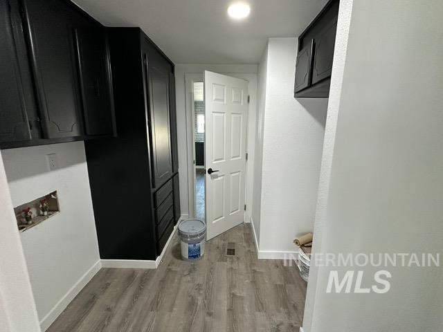 Laundry area with light wood-style flooring and washer hookup