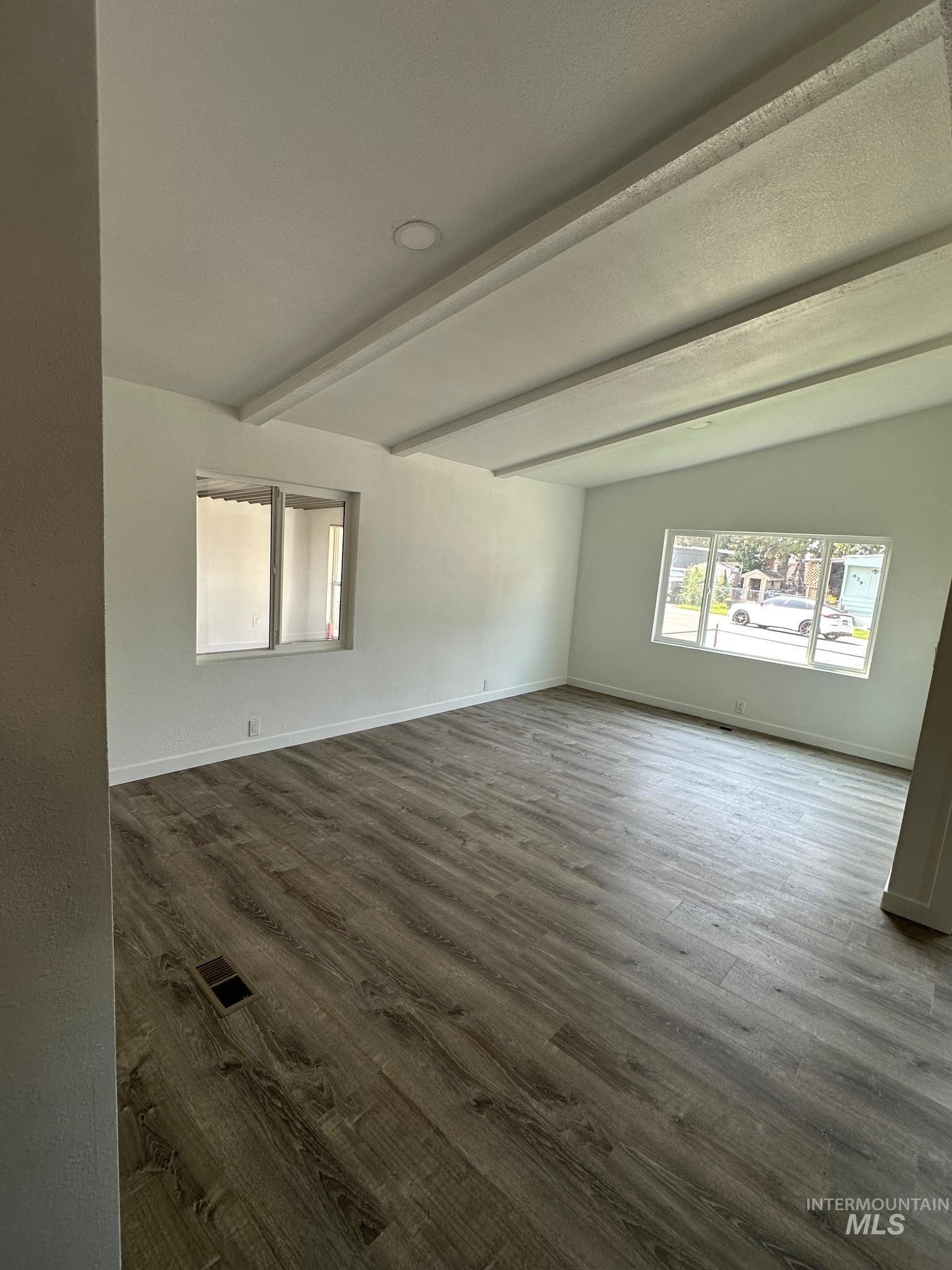 Spare room with dark wood-style flooring