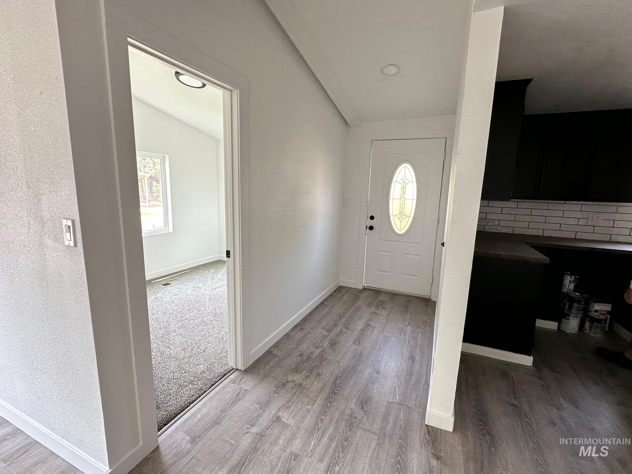 Foyer with baseboards and light wood-type flooring