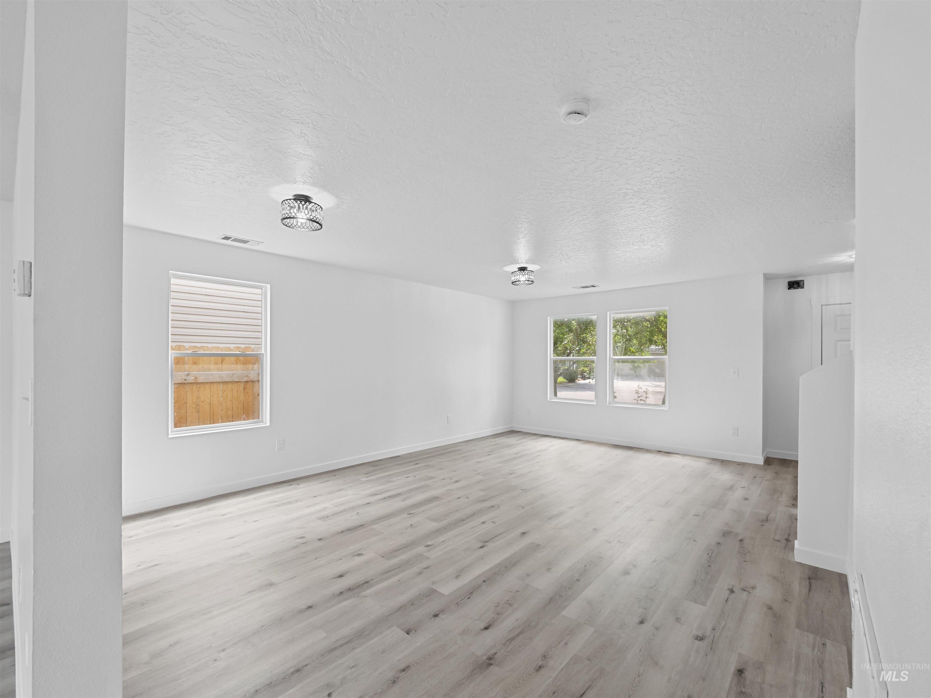 Spare room featuring a textured ceiling and light wood finished floors