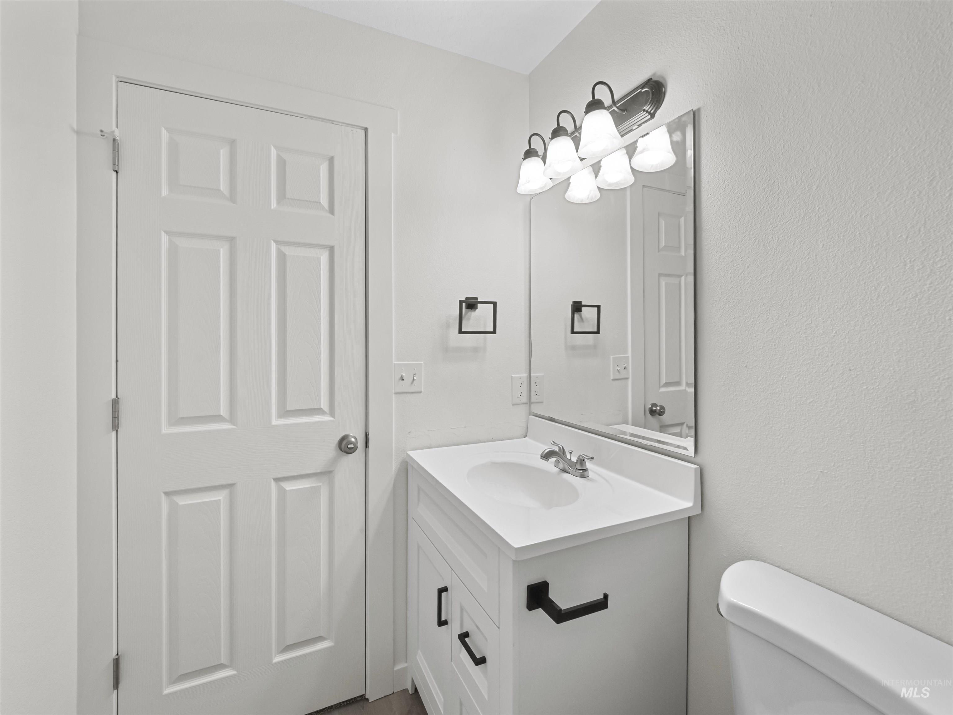 Half bath with vanity and a textured wall