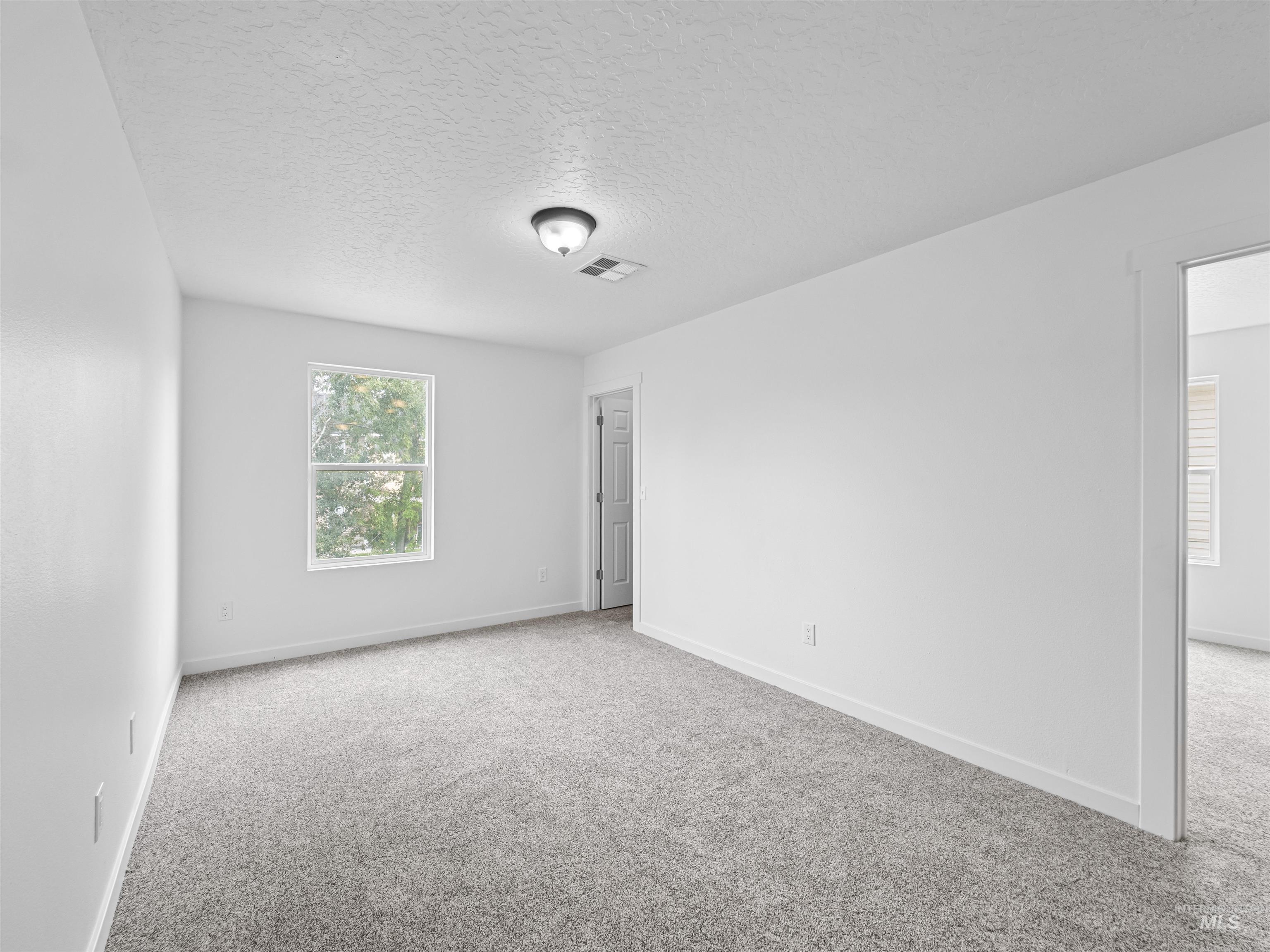 Spare room featuring carpet floors and a textured ceiling