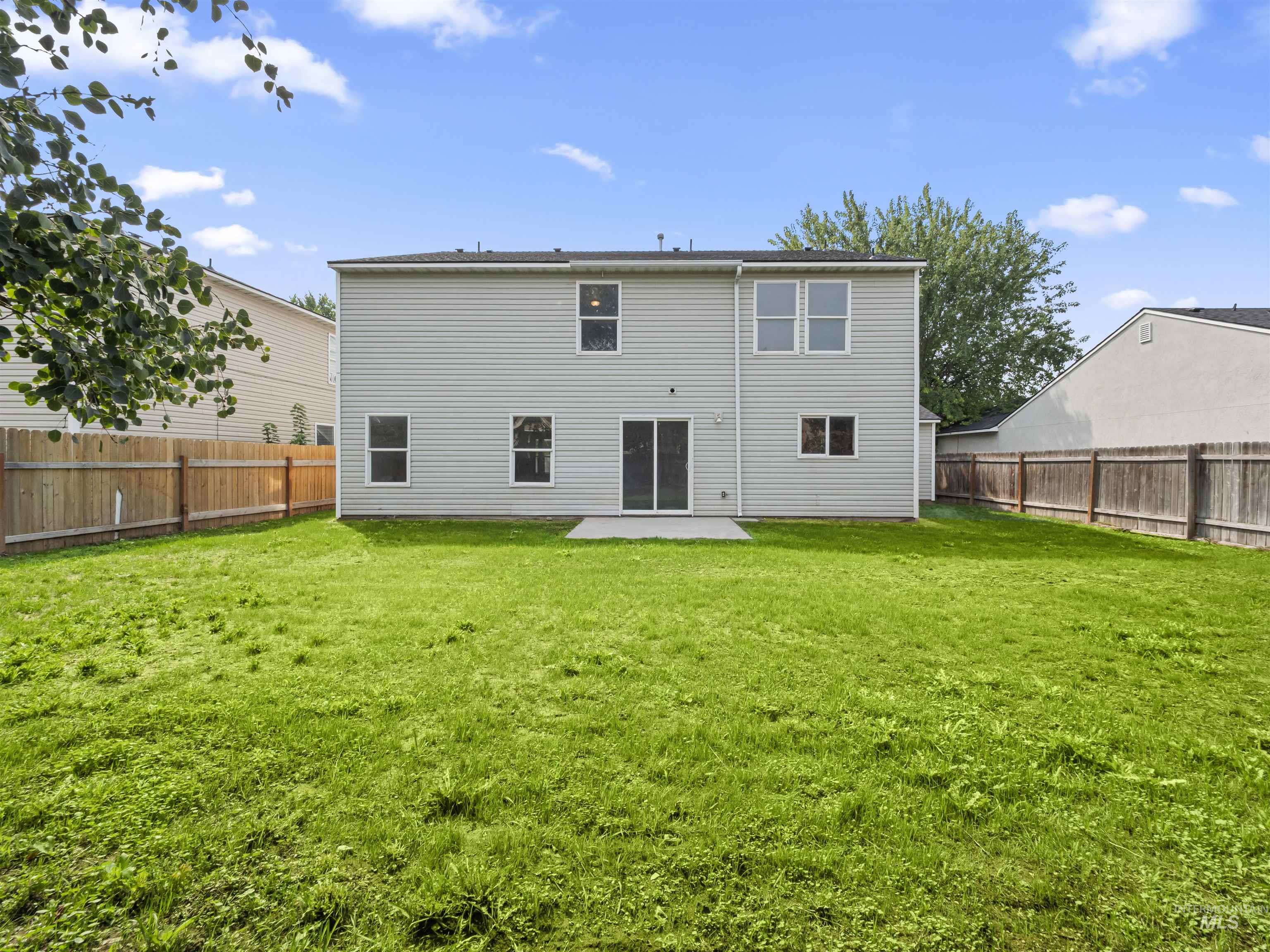 Rear view of house featuring a patio and a fenced backyard