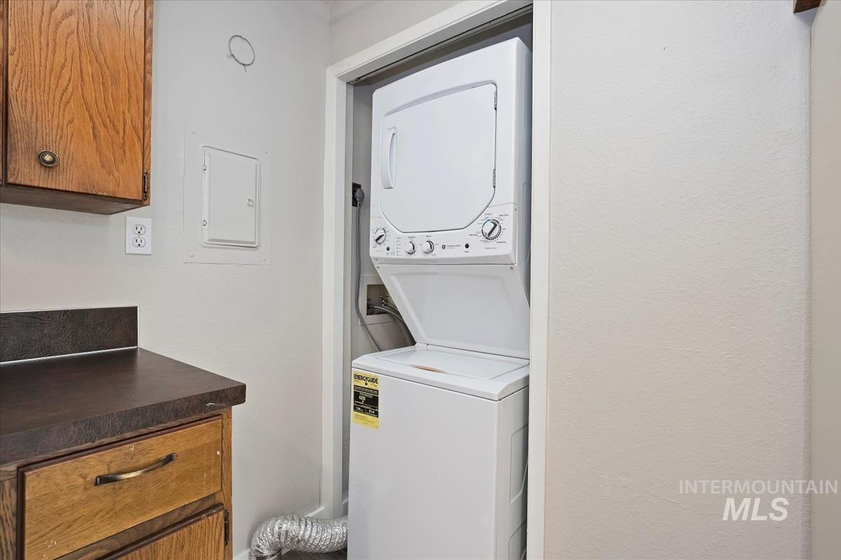 Laundry room with stacked washer / dryer and electric panel