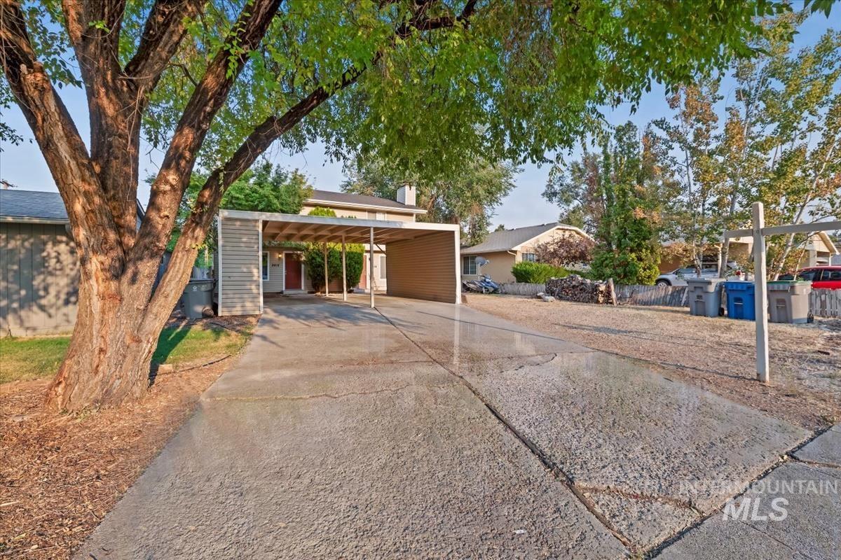 Mid-century home with concrete driveway and a chimney