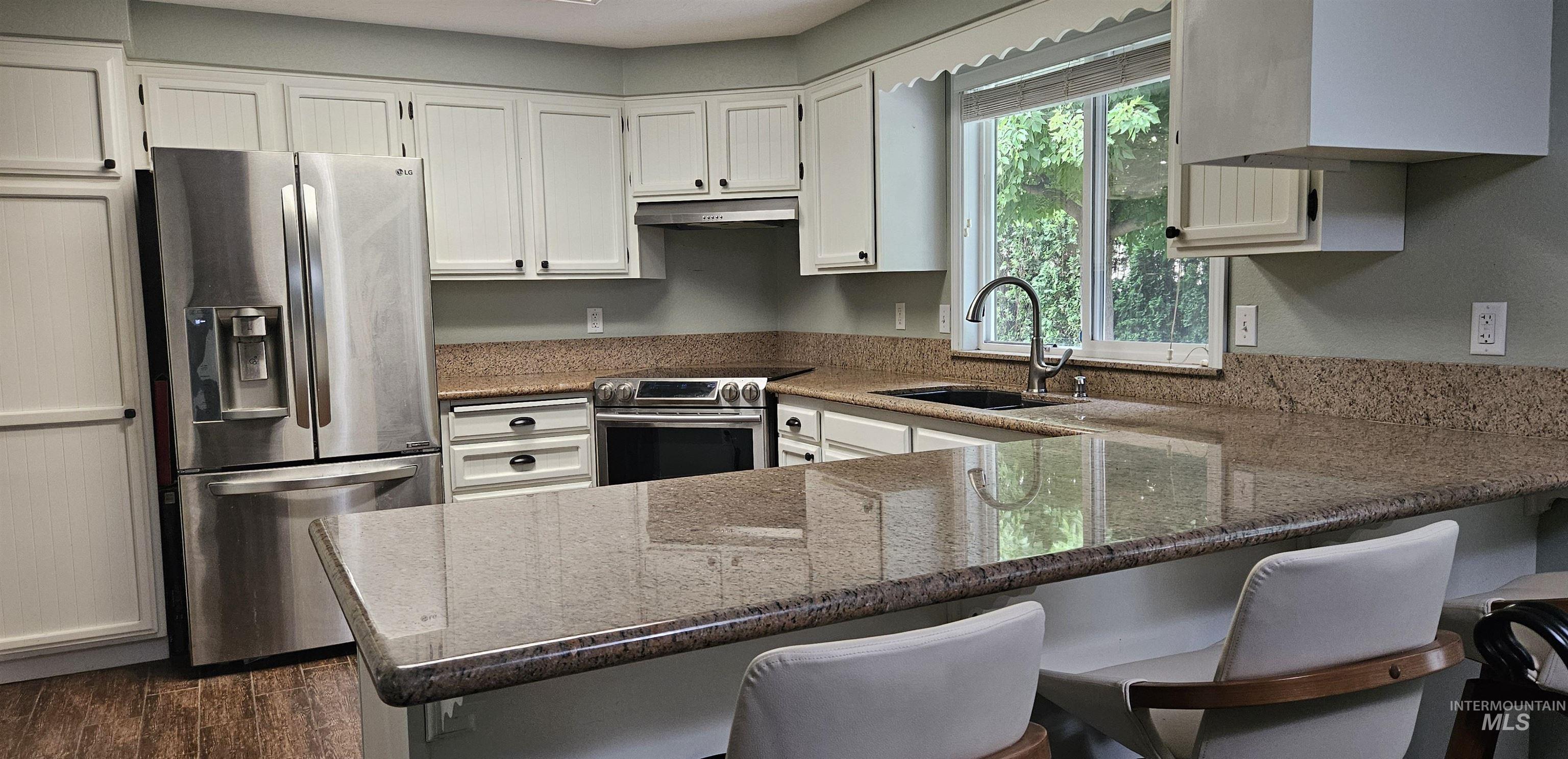 Kitchen featuring appliances with stainless steel finishes, under cabinet range hood, 