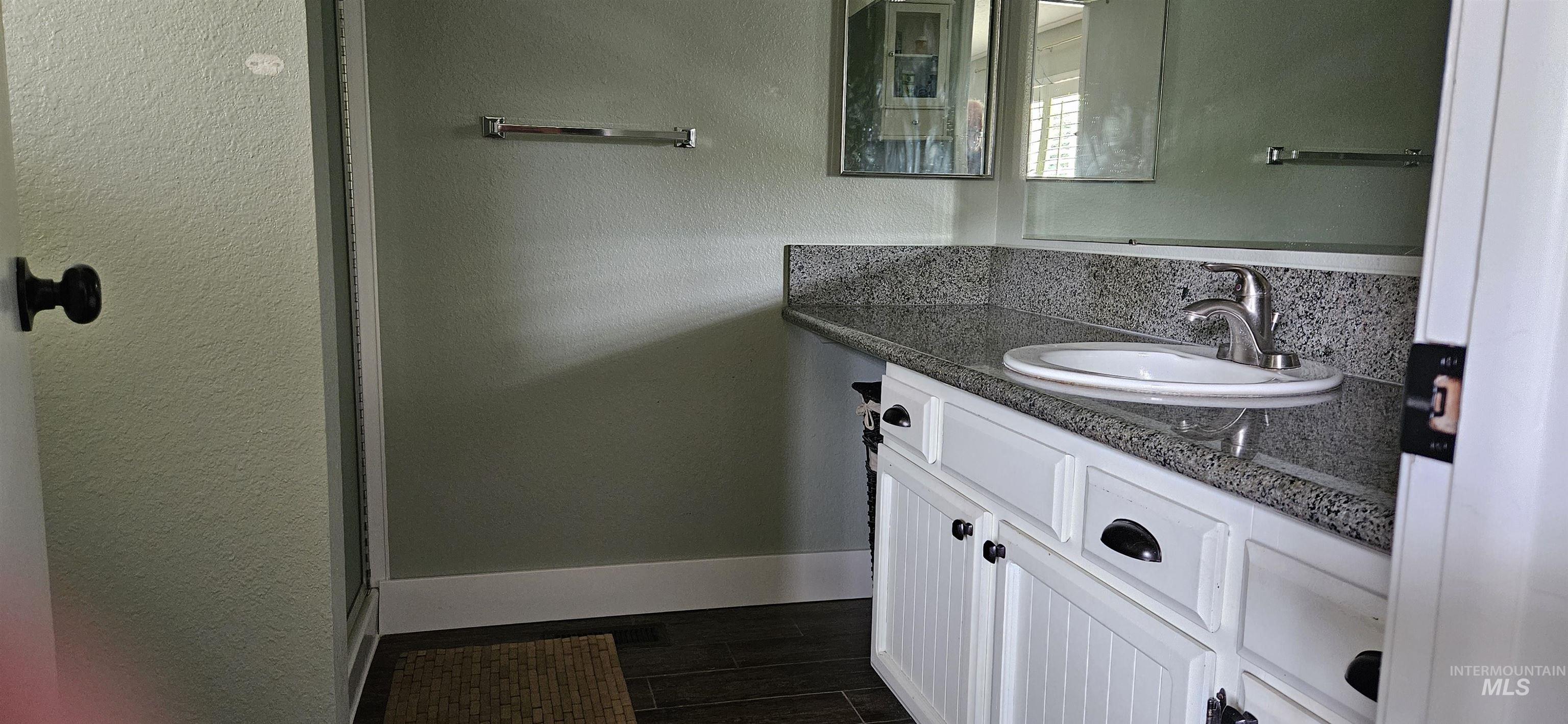 Bathroom featuring vanity and wood finished floors