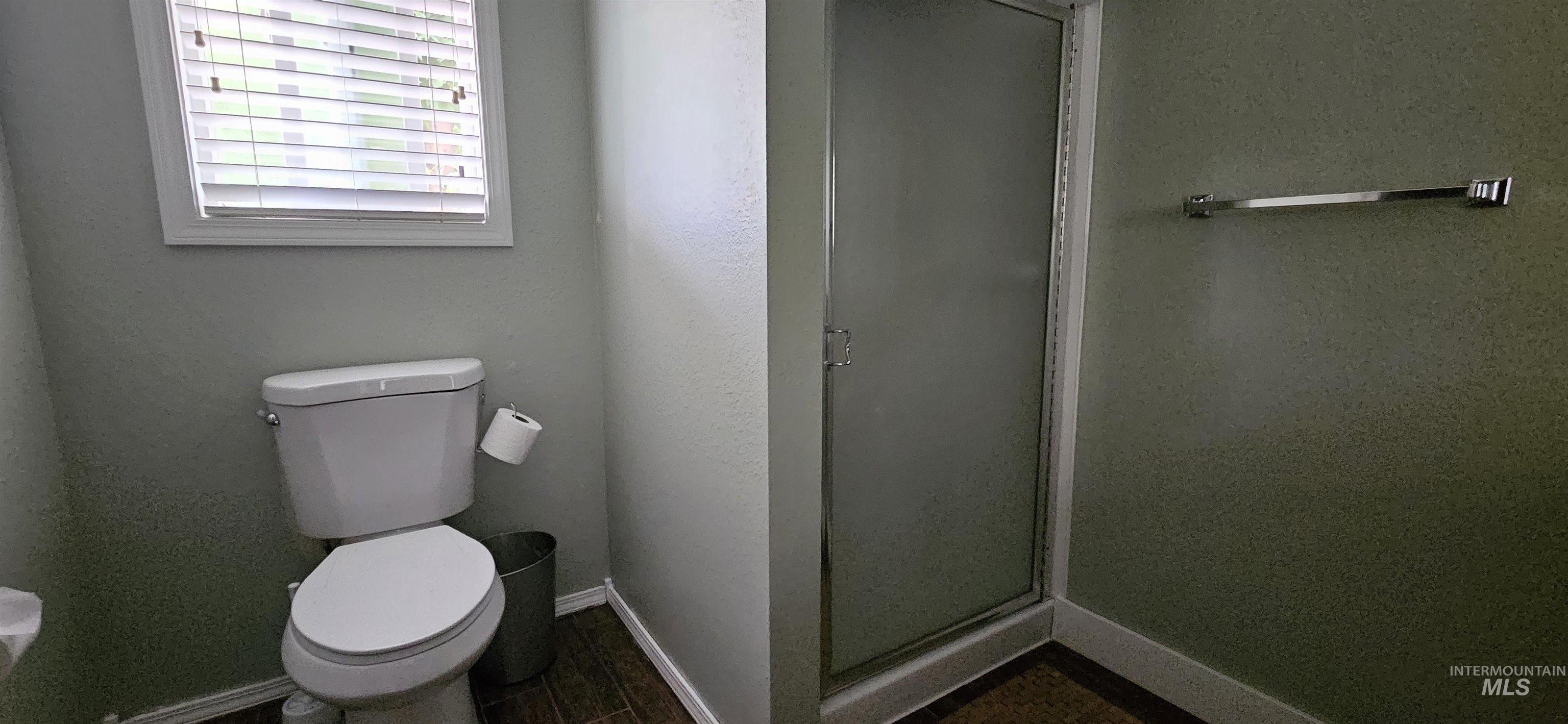 Bathroom with a shower stall and toilet