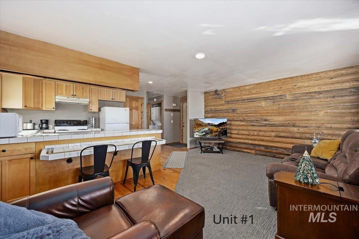 Living area featuring light wood finished floors, recessed lighting, and rustic walls