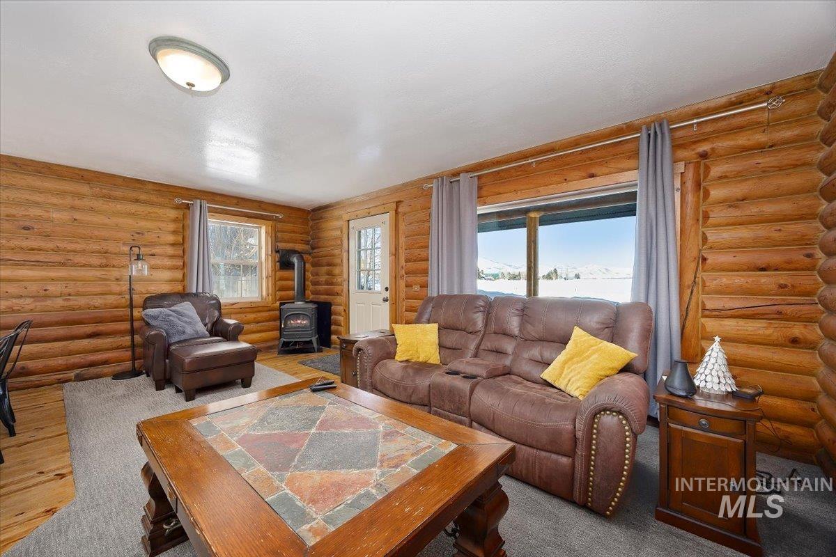 Living room featuring a wood stove and rustic walls