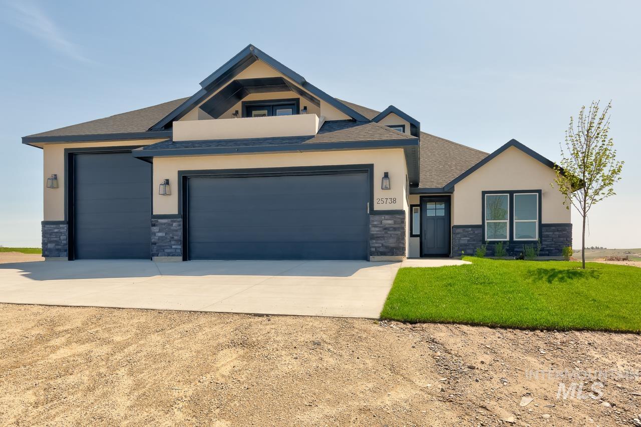View of front of home featuring stone siding, concrete driveway, stucco siding, a garage, and a shingled roof