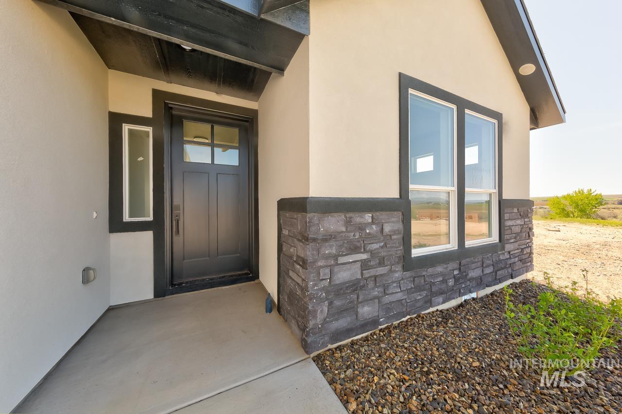 Entrance to property with stucco siding and stone siding