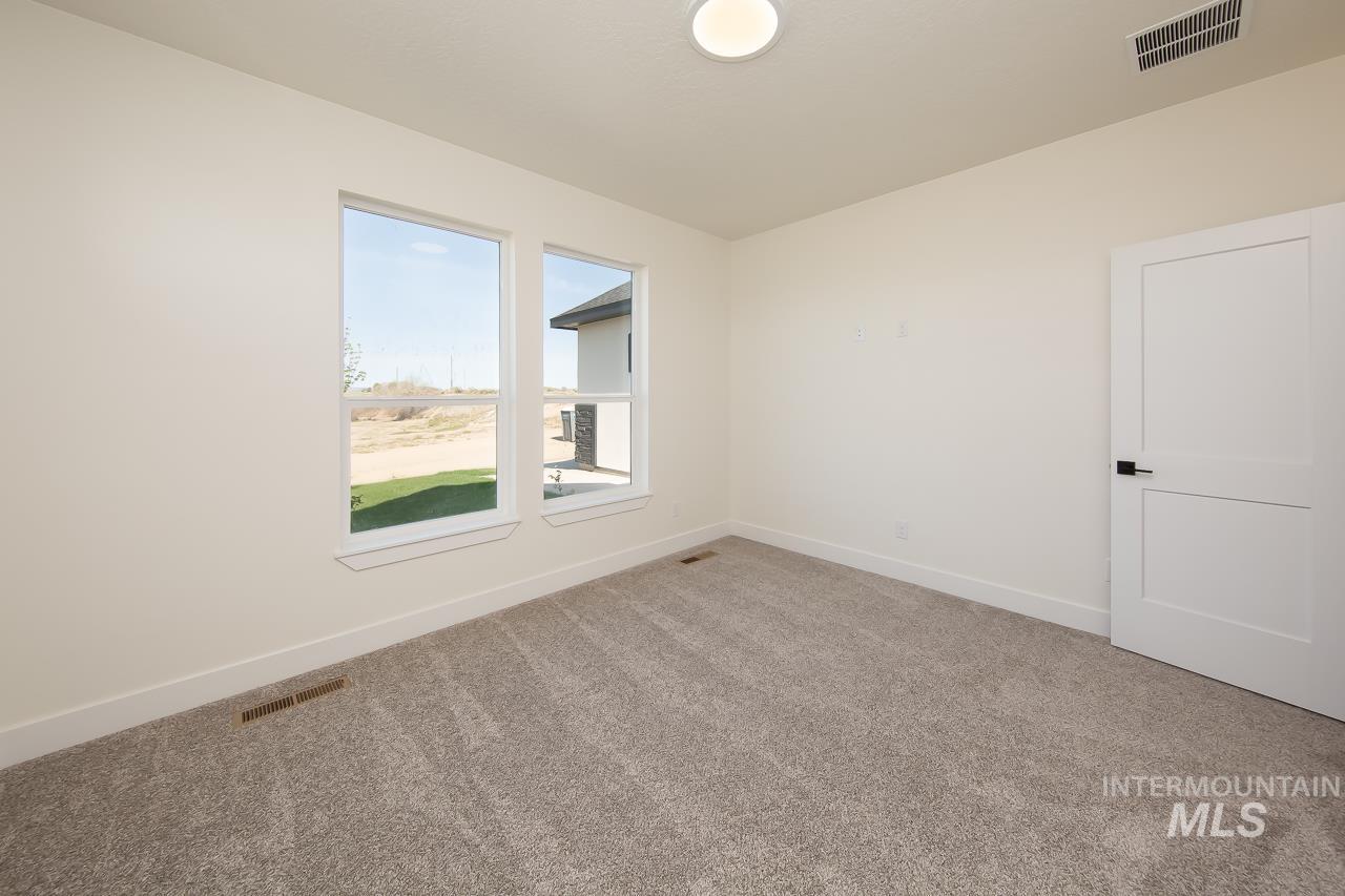 Carpeted empty room featuring baseboards