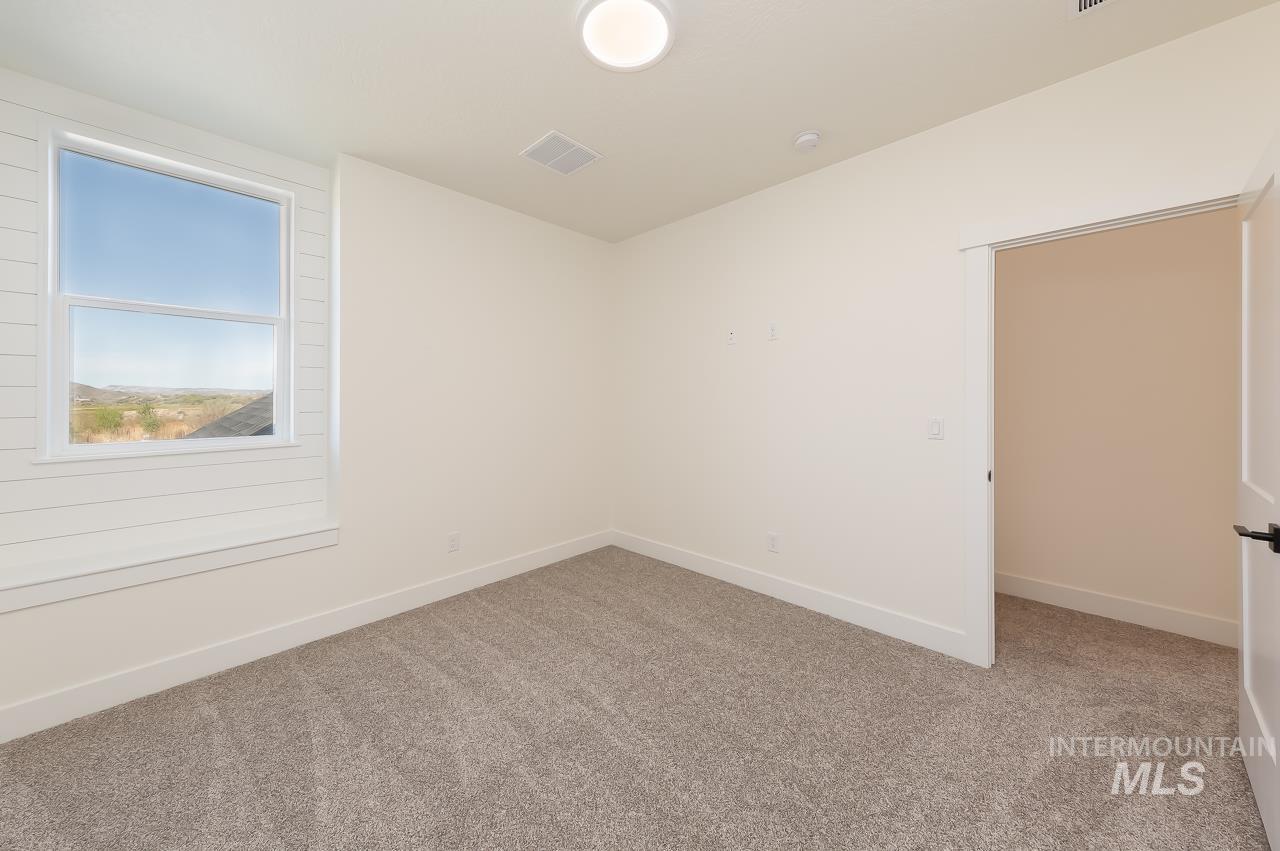 Empty room featuring light carpet and baseboards