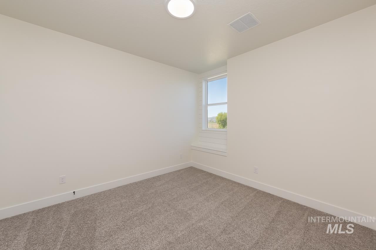 Carpeted empty room with baseboards and lofted ceiling
