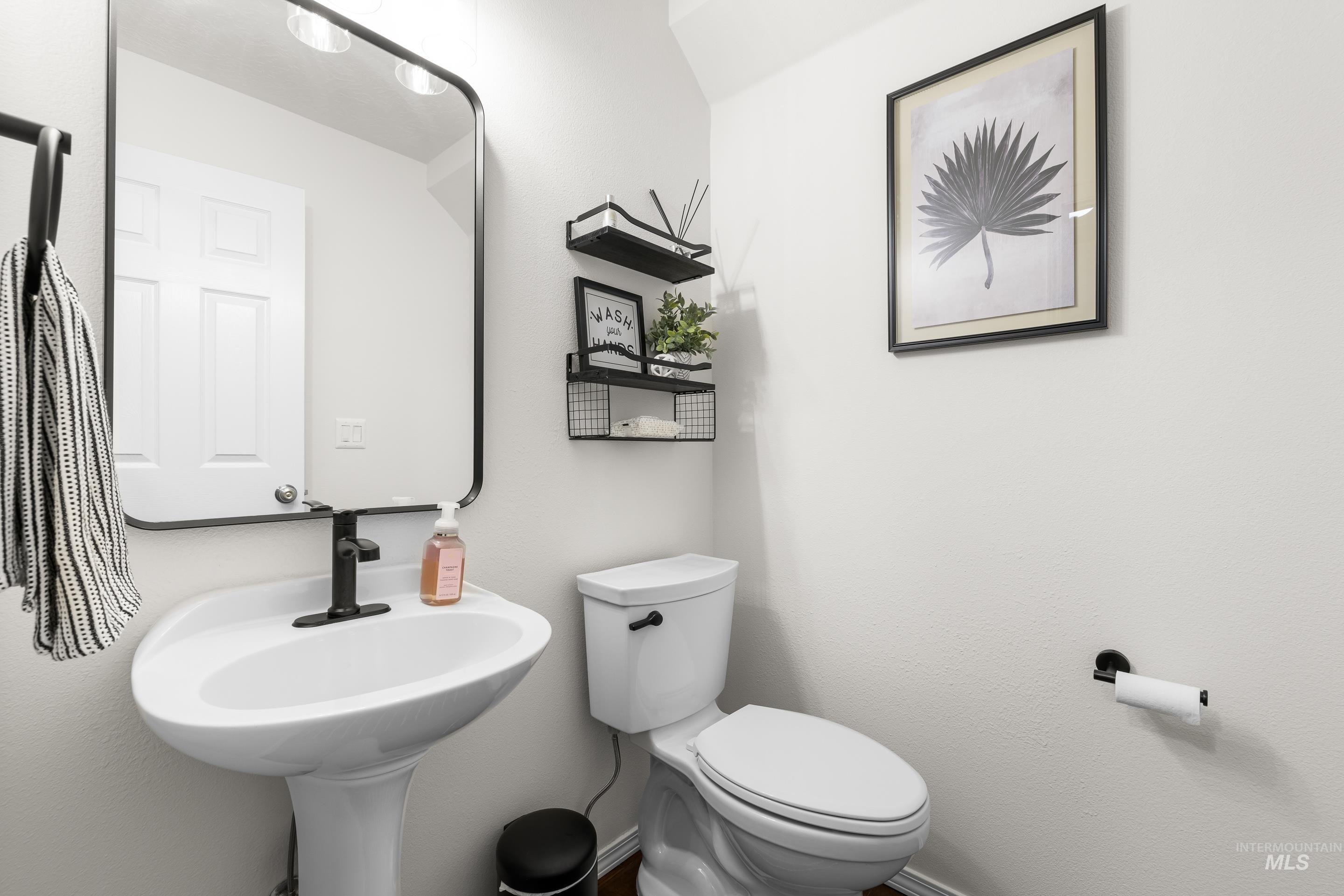 Half bathroom with toilet and baseboards